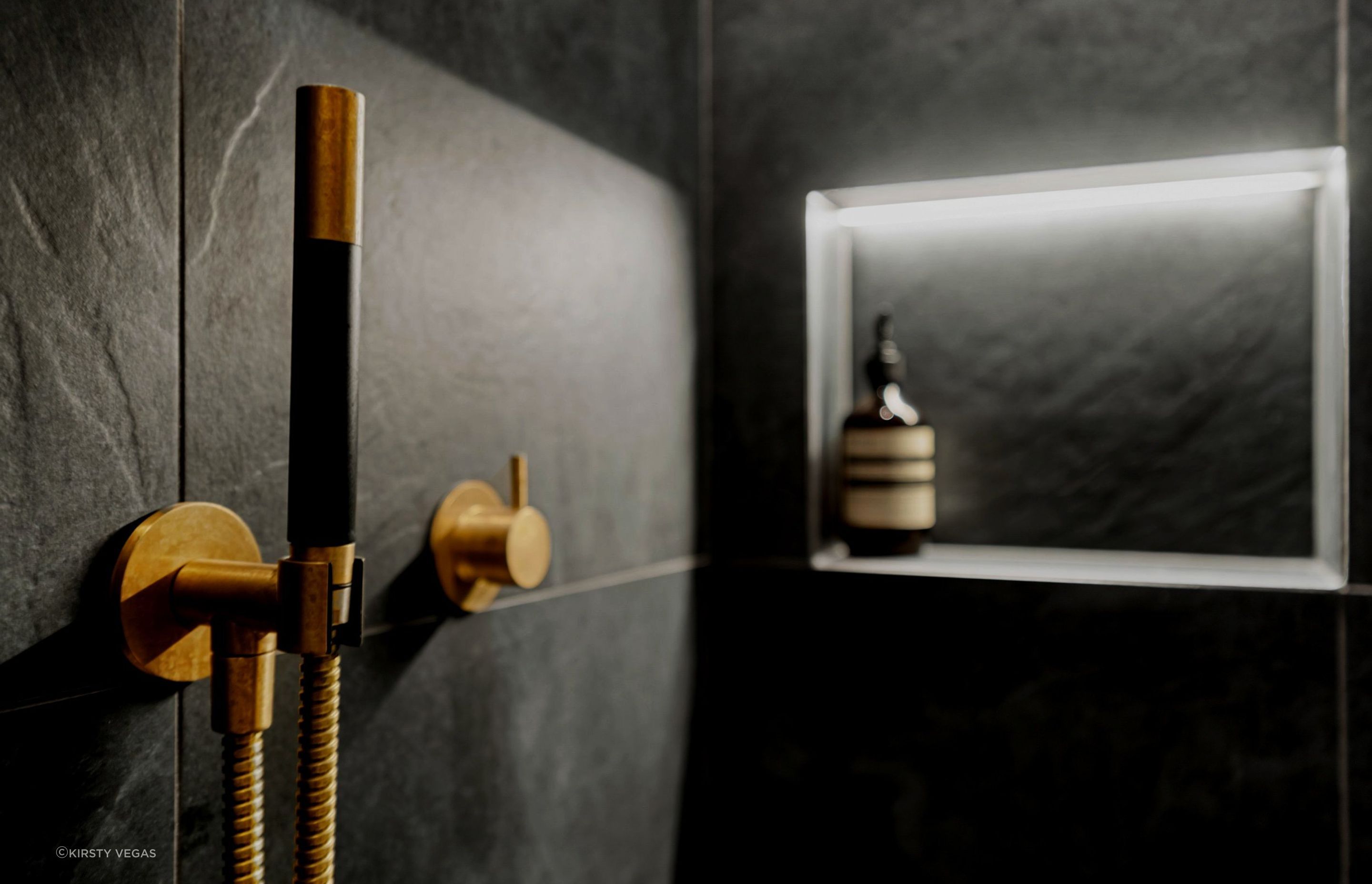 Aged brass Progetto tapware beautifully complements the sleek design of sensored recessed lighting, combining elegance with modern functionality..