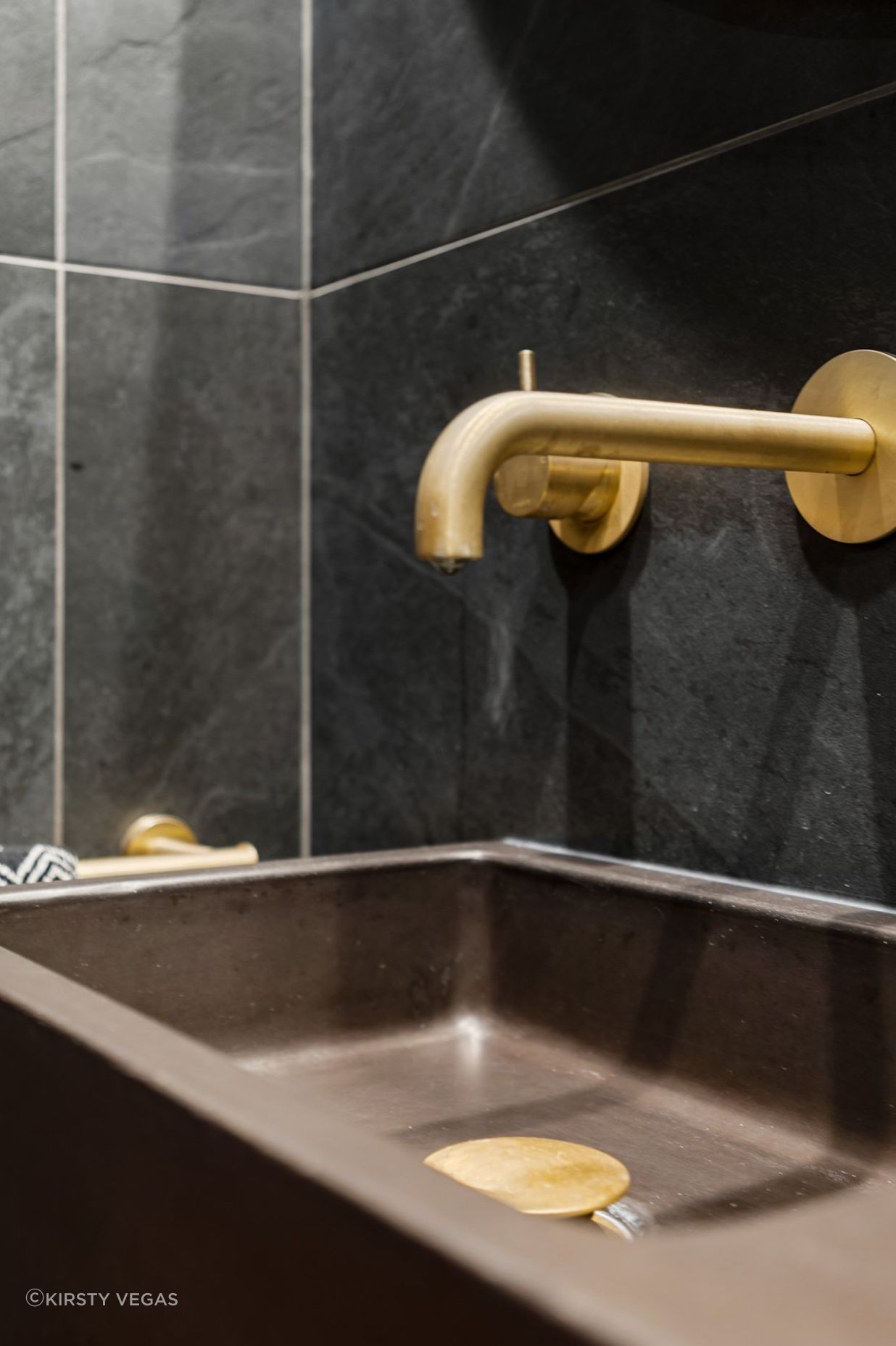 A thoughtfully curated combination features a striking Concrete Nation vanity, complemented by aged brass Progetto tapware and a stylish Missoni (Keith) hand towel, creating a perfect blend of modern design and timeless elegance.