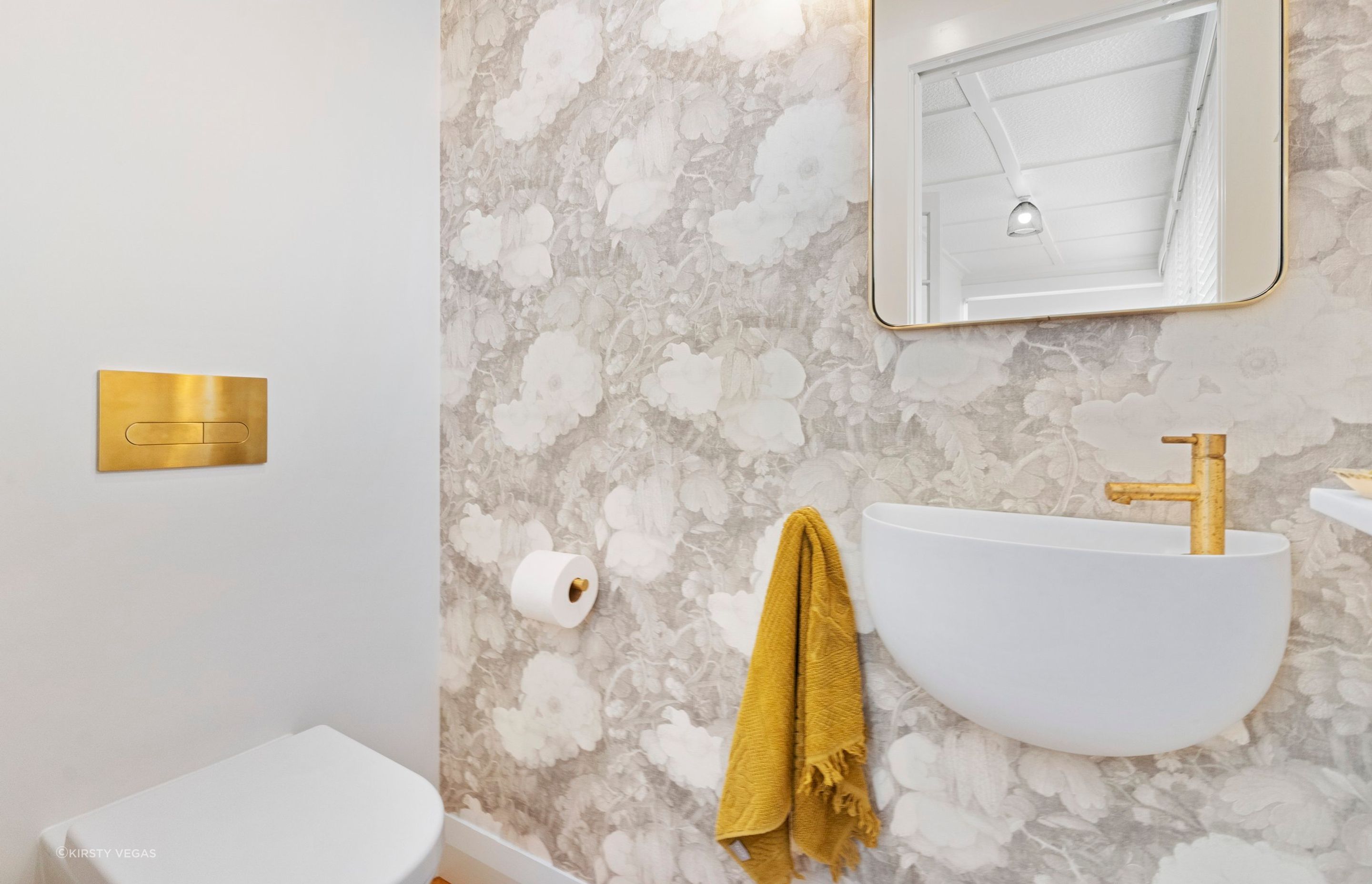 The floral design of this custom linen wallpaper imparts a distinctive and tranquil ambiance to the powder room, transforming it into a serene haven. The delicate patterns and soft colors create a soothing backdrop that enhances the overall aesthetic, inviting relaxation and a sense of peace. This beautiful feature adds character and charm, making the powder room a truly special space where guests can feel at ease.
