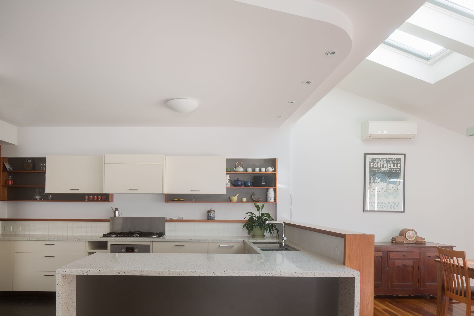 Modern kitchen with timber detailing, and a light gentle green tiled splash back.