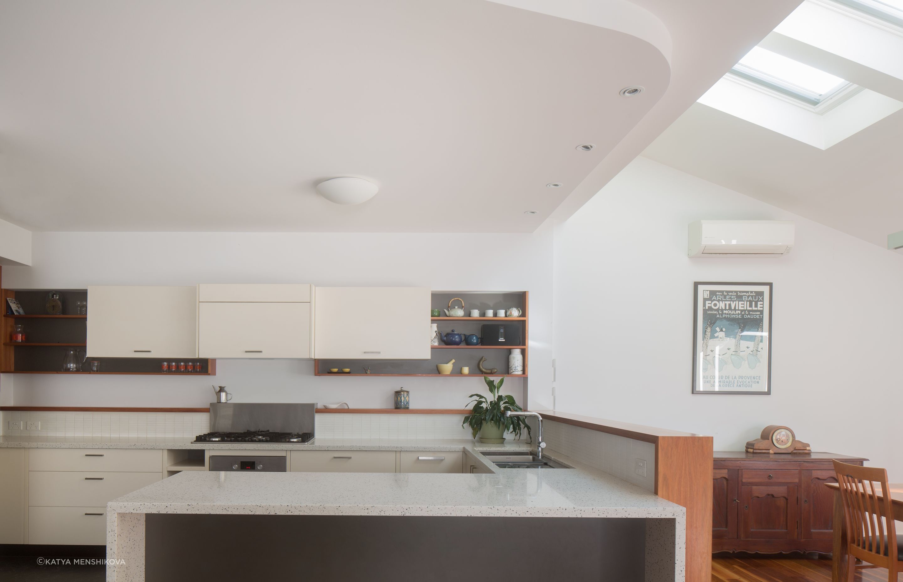 Modern kitchen with timber detailing, and a light gentle green tiled splash back.