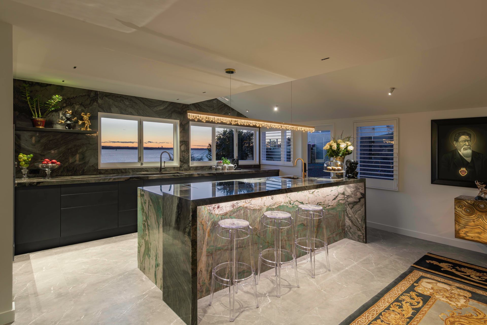 This Viridian stone is formed into a bold island block then bravely encapsulated with yet another equally artistic dark stone frame to create a breakfast bar. Its textural pattern echoes Heather Straka Maori portraits adjacent while its monochromatic expression allows the jade Viridian stone centre stage. Together the two ancient materials interlock to create a distinctive sculpture of richness and colour.