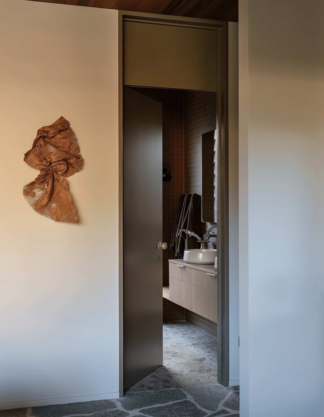 In the bathrooms, Novara Technifirma mimics the ambient movement of flecked terrazzo while Nacre glass mosaic tiles add vibrant green sparkle to the organic-shaped pool.