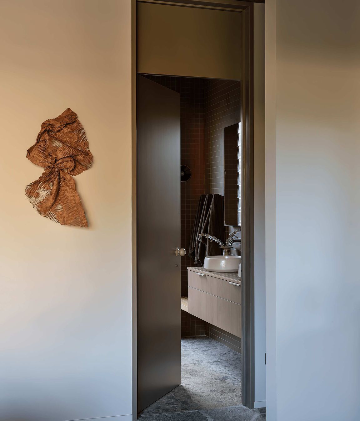 In the bathrooms, Novara Technifirma mimics the ambient movement of flecked terrazzo while Nacre glass mosaic tiles add vibrant green sparkle to the organic-shaped pool.