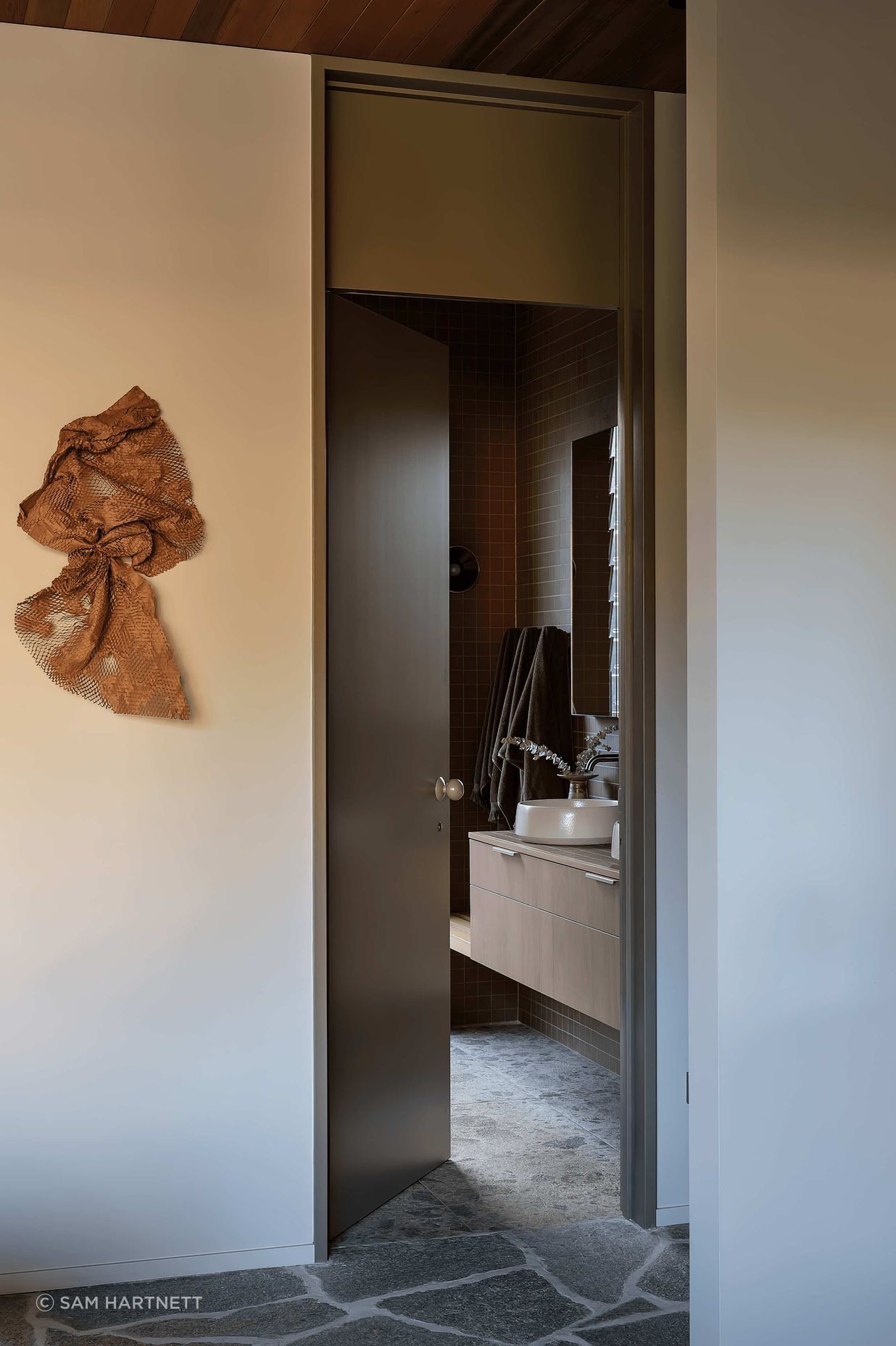 In the bathrooms, Novara Technifirma mimics the ambient movement of flecked terrazzo while Nacre glass mosaic tiles add vibrant green sparkle to the organic-shaped pool.