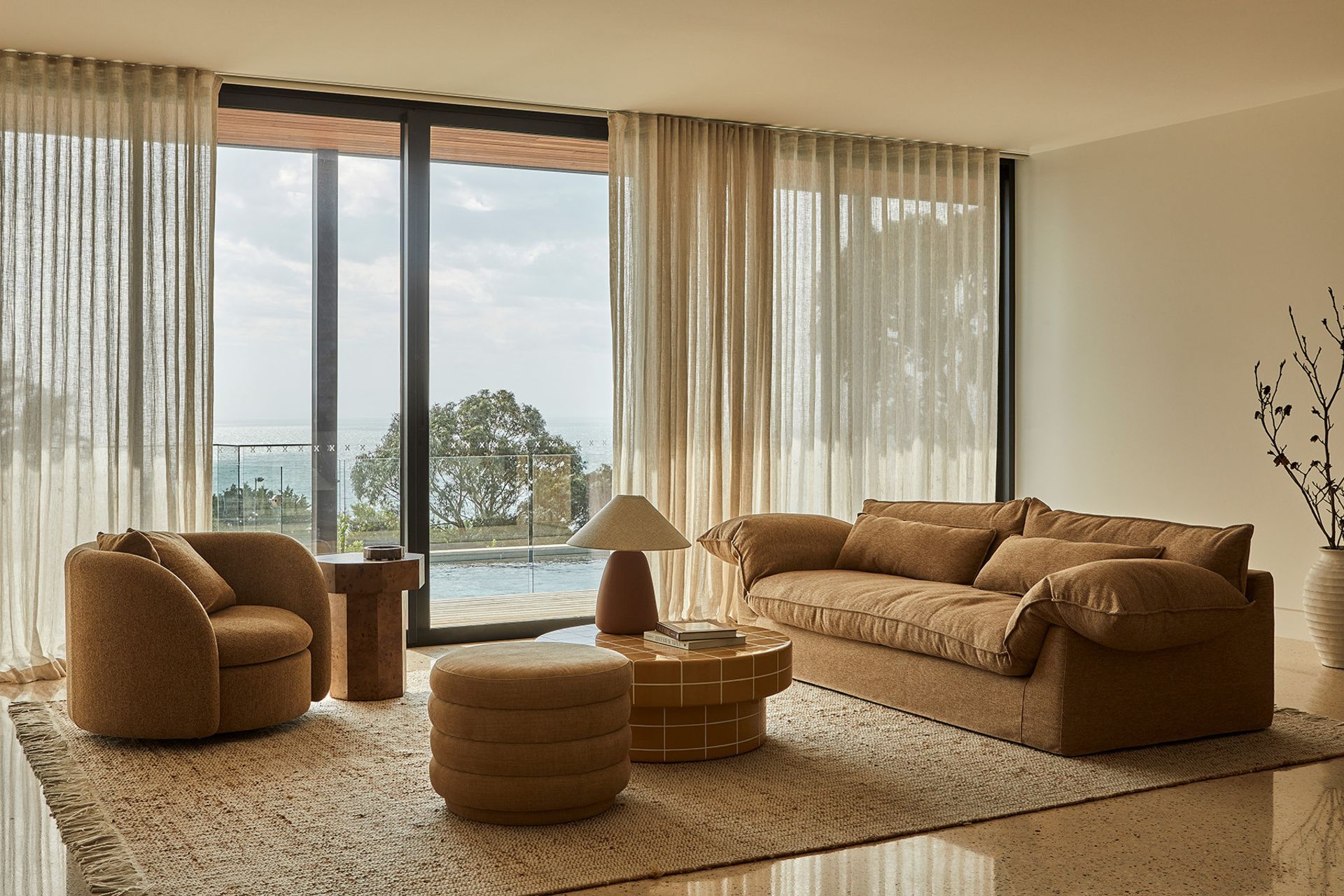 Pictured: Vittoria Como 3 Seat Sofa, Juno Orb Sofa Chair, Seville Tile Round Coffee Table, Kennedy Ribbed Round Ottoman, Trove Burl Side Table, Lorne Pebble Table Lamp, Rufus Ares Bowl