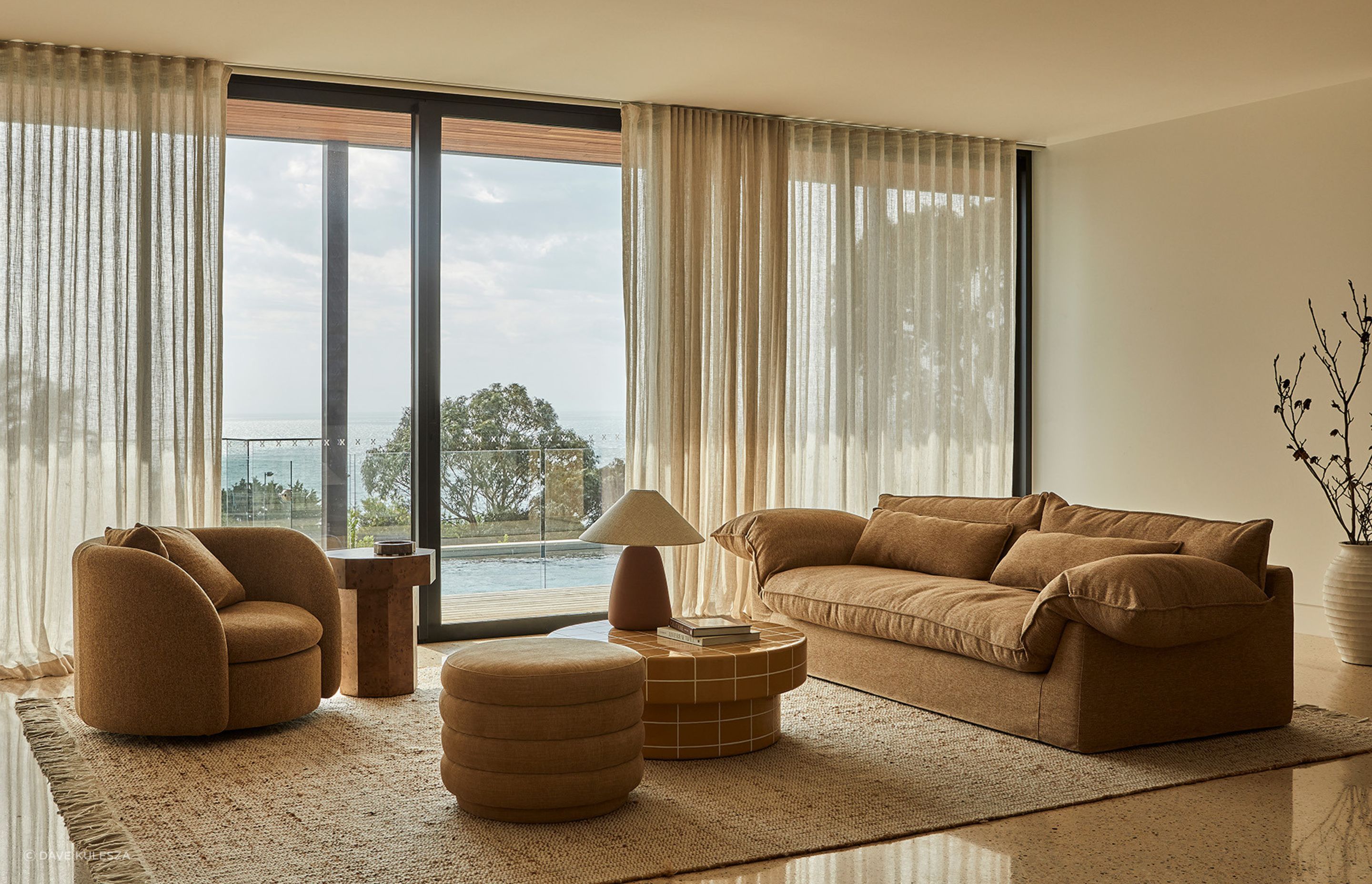 Pictured: Vittoria Como 3 Seat Sofa, Juno Orb Sofa Chair, Seville Tile Round Coffee Table, Kennedy Ribbed Round Ottoman, Trove Burl Side Table, Lorne Pebble Table Lamp, Rufus Ares Bowl