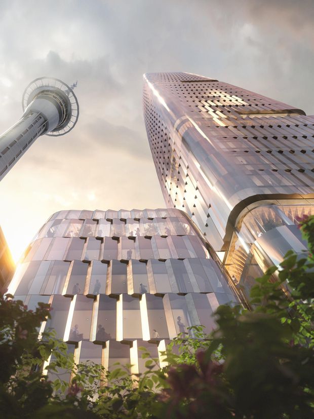 Low-angle exterior view of a tall contemporary high-rise complex with rounded corners and reflective metallic façades. The main tower features a perforated geometric skin and extensive glazing, while a distinctive circular observation or communications tower rises on the left. Landscaped foliage partially frames the base, and warm late-day light reflects across the building surfaces.