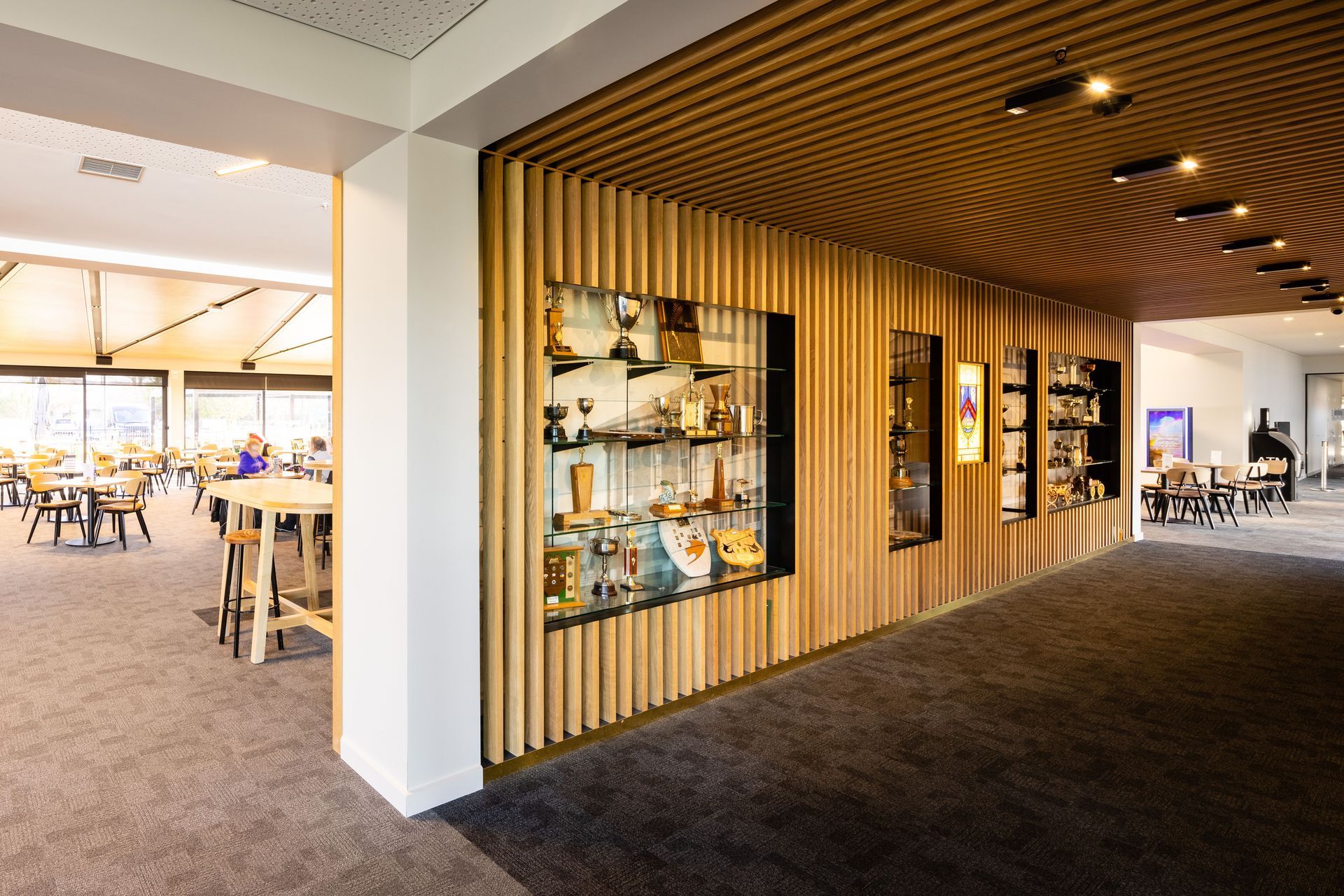 Timber battens frame the club's trophies and other memorabilia and provide contrast to the crisp white walls. Photography by Clinton Lloyd.