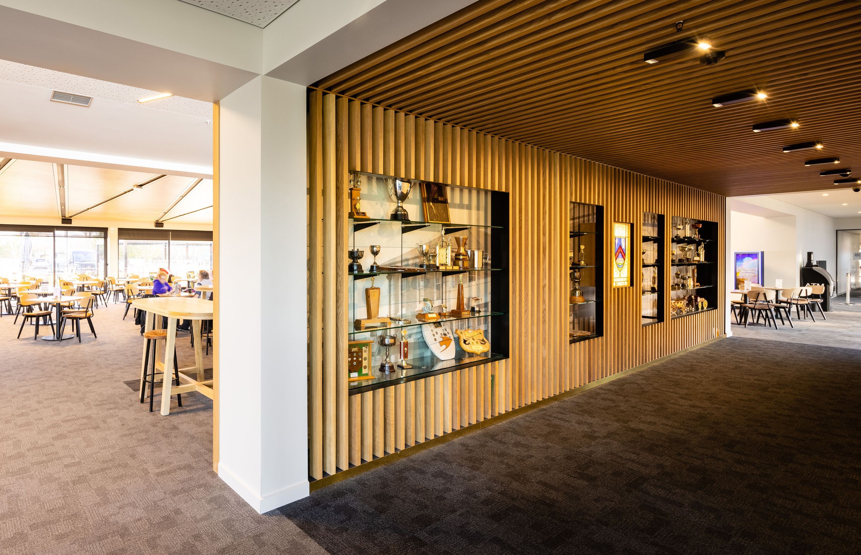 Timber battens frame the club's trophies and other memorabilia and provide contrast to the crisp white walls. Photography by Clinton Lloyd.