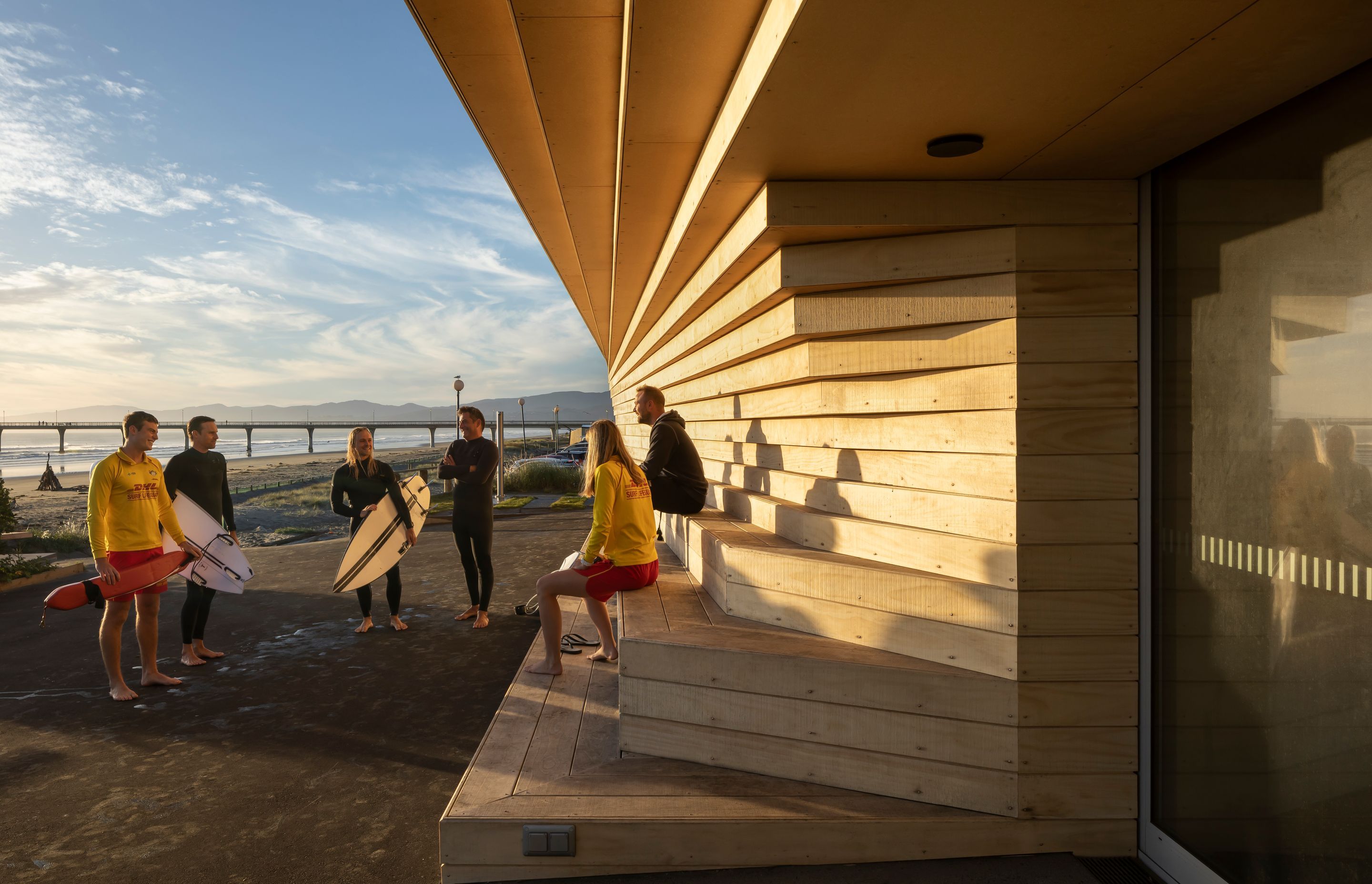 Beyond the Surf Lifesaving Club, the iconic New Brighton pier juts out into the sea.