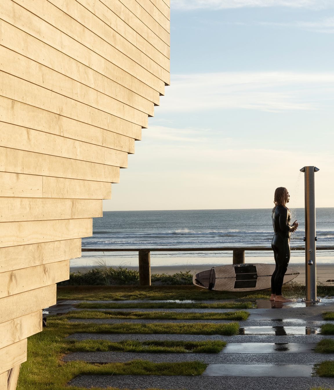 A surfer enjoys an outdoor shower at the front of the building. Ken says the beautiful new building hasn't suffered any tagging, and he often sees members of the community gather outside for morning coffee to interact and enjoy the facility.