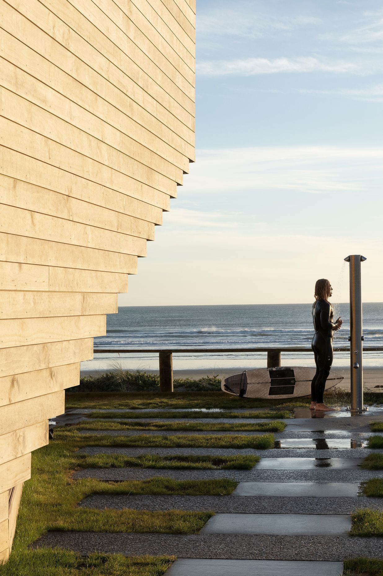 A surfer enjoys an outdoor shower at the front of the building. Ken says the beautiful new building hasn't suffered any tagging, and he often sees members of the community gather outside for morning coffee to interact and enjoy the facility.
