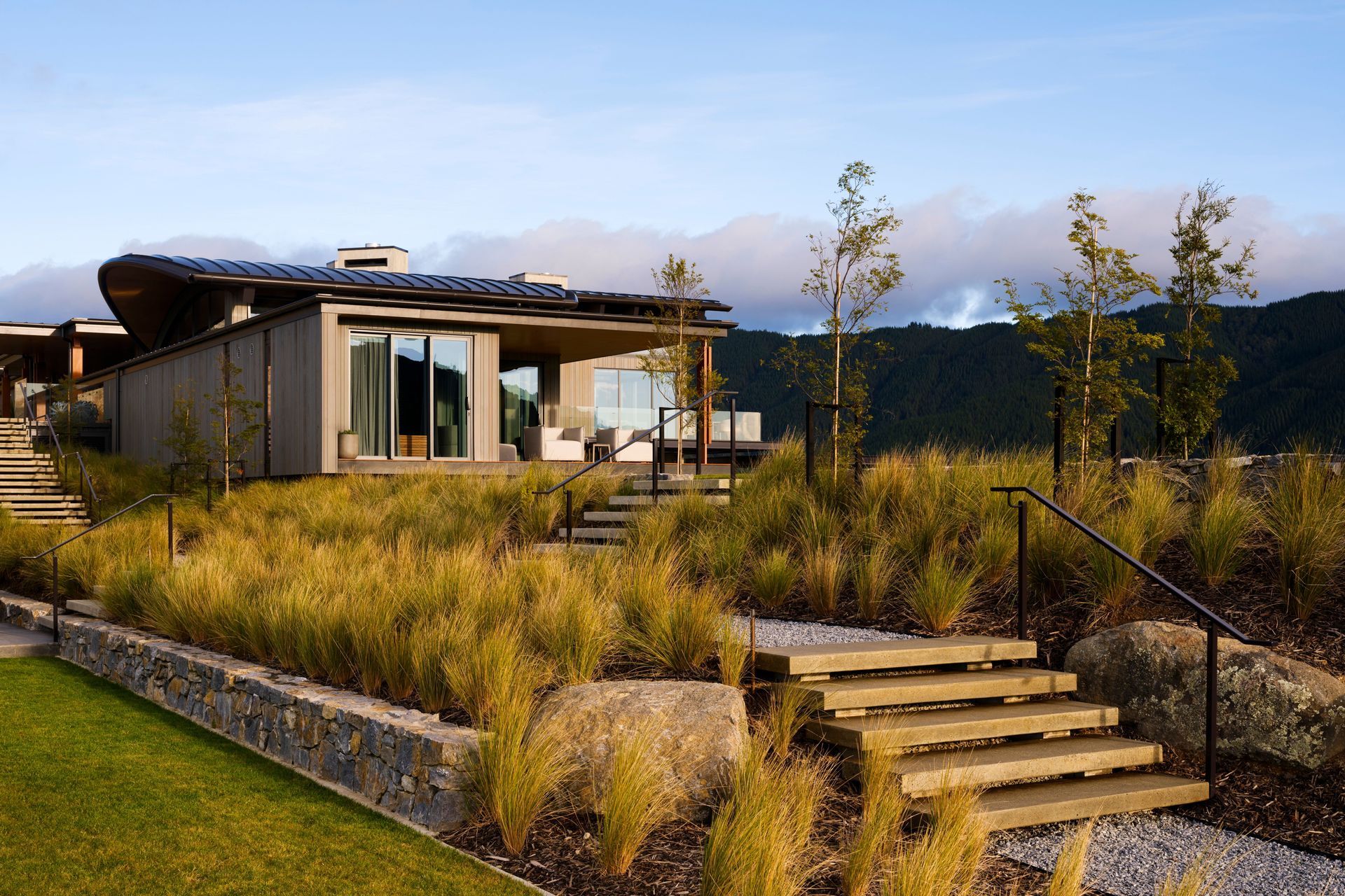 Due to the typology and elevation of the site, as well as the climate, the landscaping features a theme of regeneration with a palette of native New Zealand plants as the backdrop.