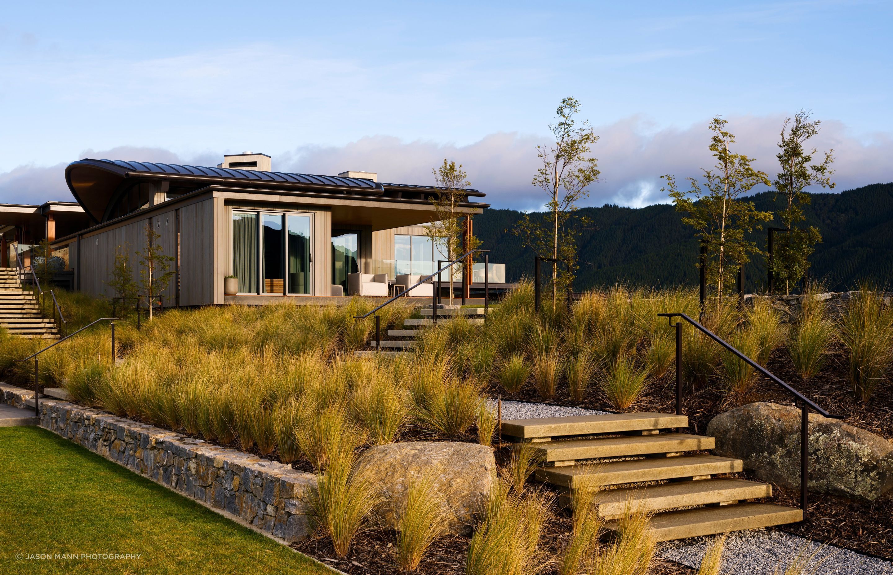 Due to the typology and elevation of the site, as well as the climate, the landscaping features a theme of regeneration with a palette of native New Zealand plants as the backdrop.