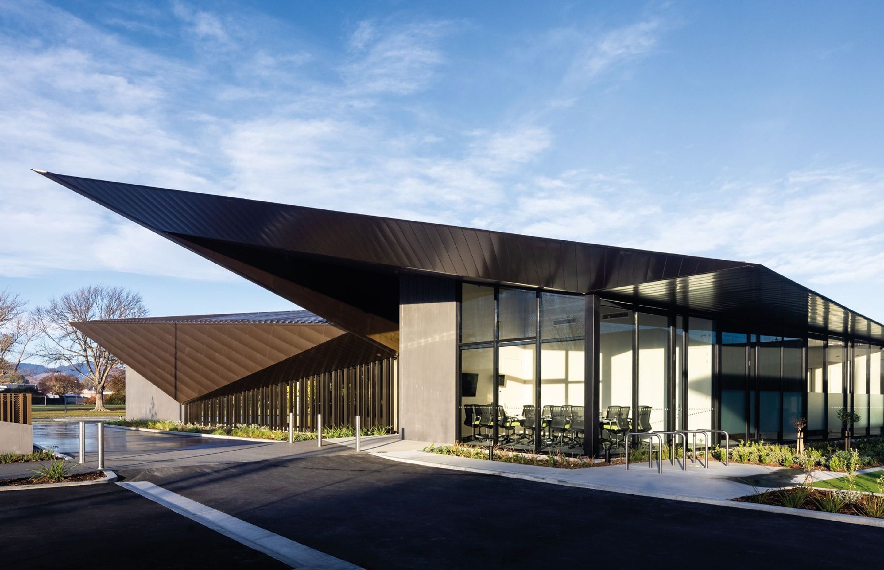 Large areas of glazing and aluminium and counterbalanced by precast elements, which serve to visually anchor the structure to the site. Photography by Clinton Lloyd.