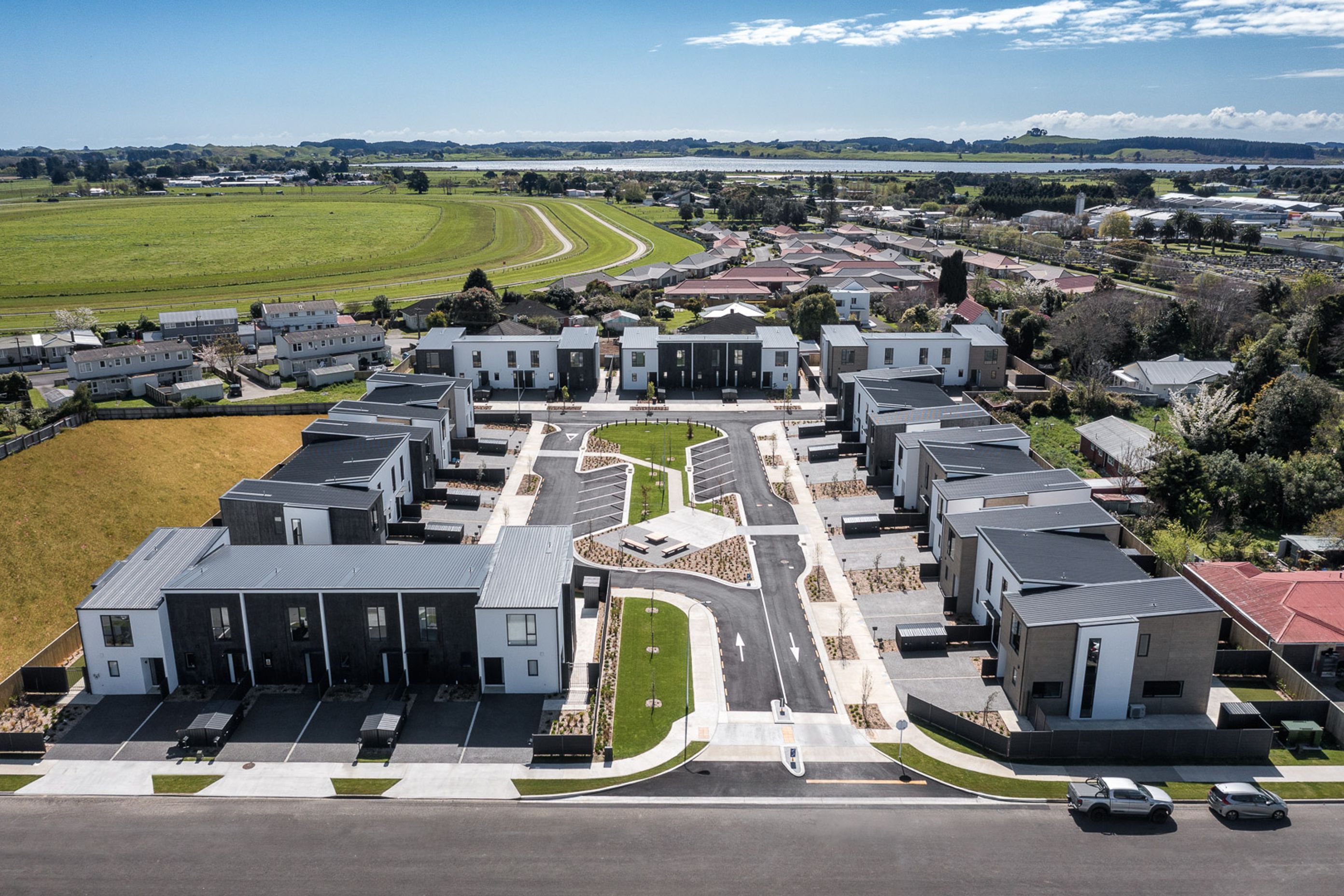 New housing development with varying roof forms and building textures surrounding central community space