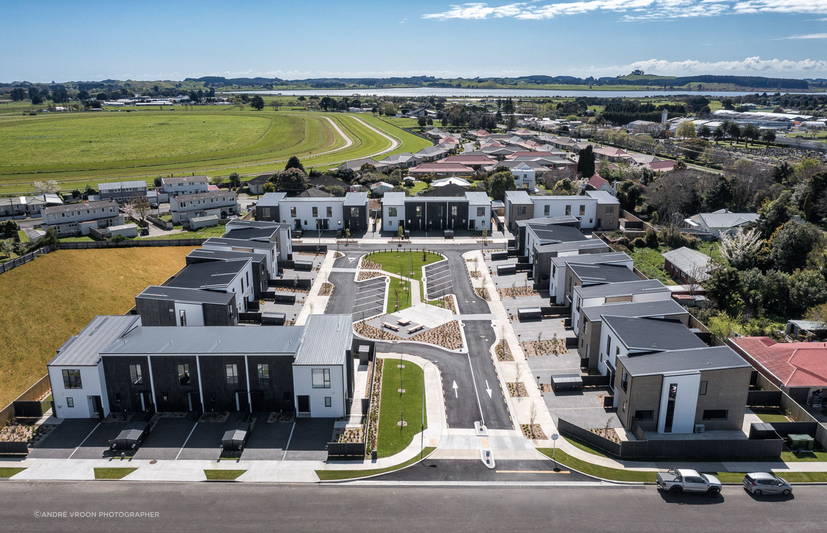 New housing development with varying roof forms and building textures surrounding central community space