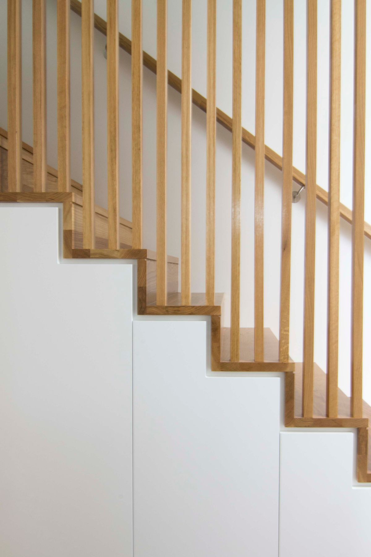 A seamless detail to the staircase and balustrade junction. Concealed storage below stairs to maximise use of space.