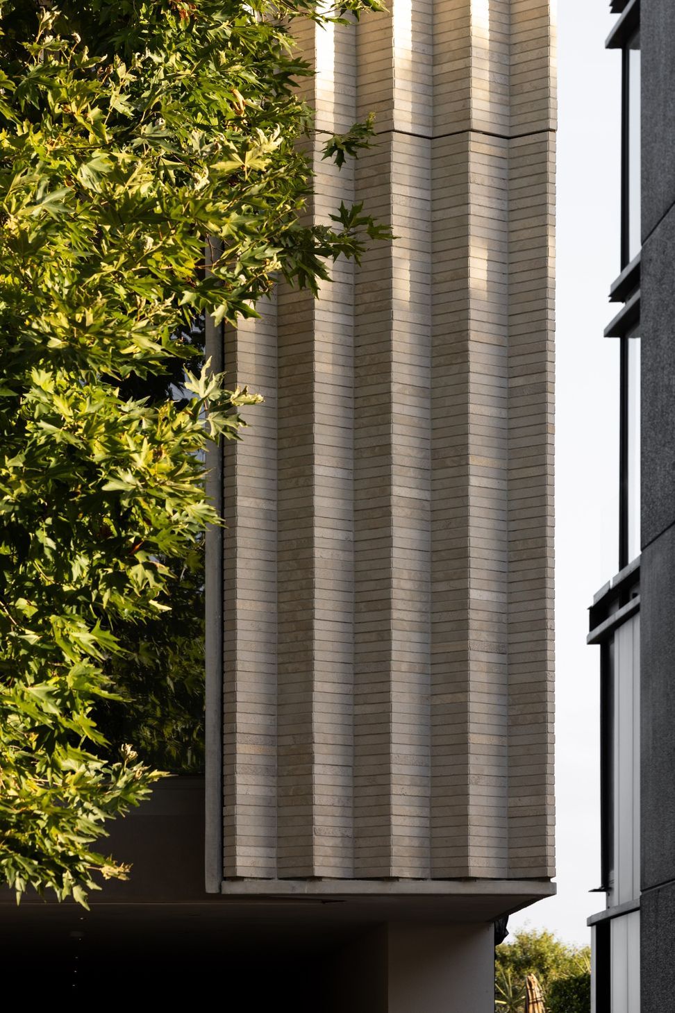 Vertical-folds-in-the-limestone-brick-facade-give-Jervois-Road-its-carved-architectural-expression-softening-the-scale-of-the-five-level-building-within-its-residential-sett.jpg
