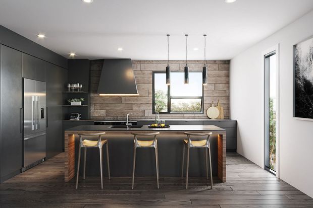 A contemporary kitchen with a dark charcoal and timber palette. The room features a large central island with seating for three, integrated dark cabinetry and stainless-steel refrigeration, a black benchtop, pendant lights, a sculptural rangehood, and a horizontal timber feature wall around the window. Dark timber-look flooring and white walls complete the clean, modern interior.