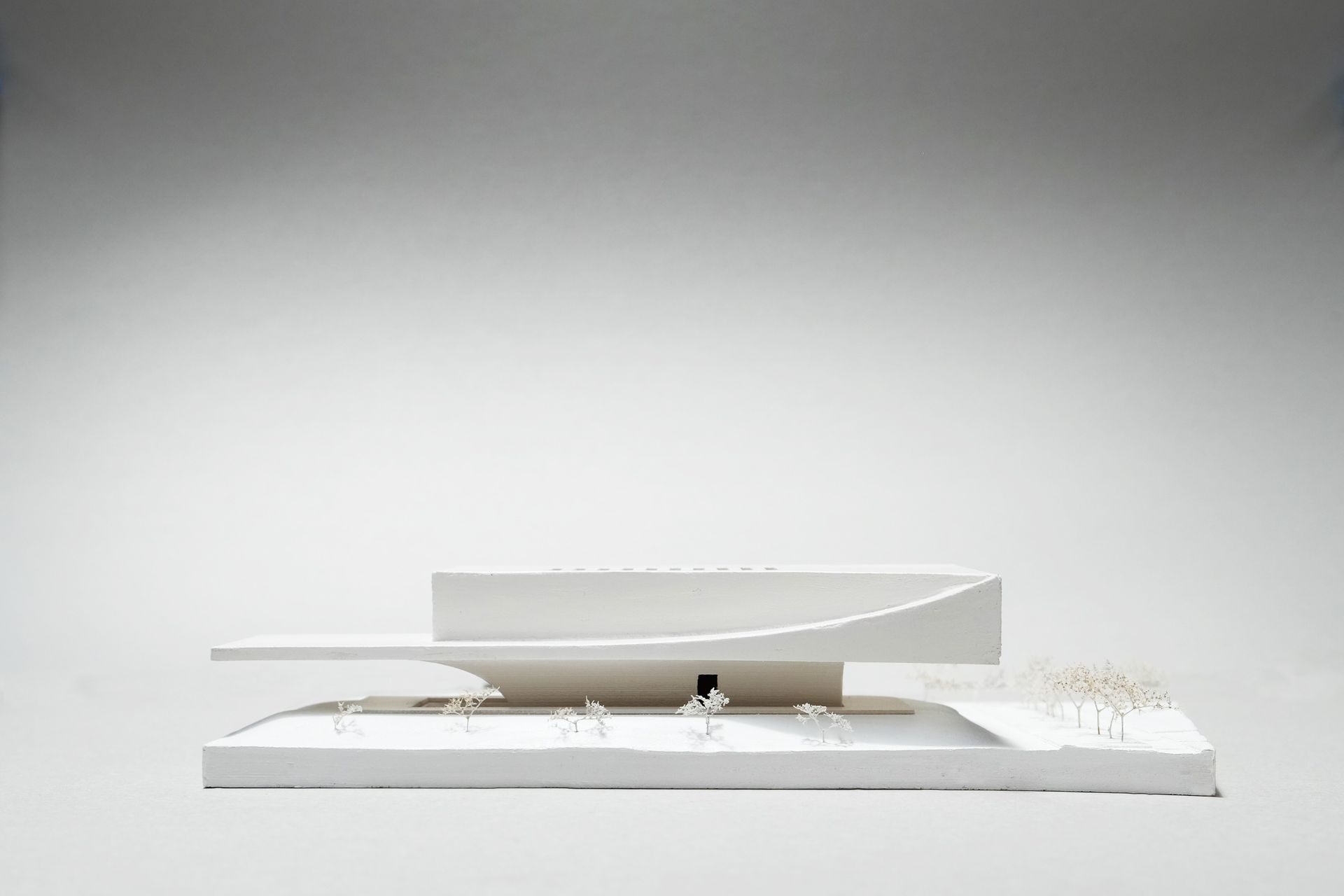 Primary gallery spaces are located within the upper level, over a transparent groundplane with front of house and social functions