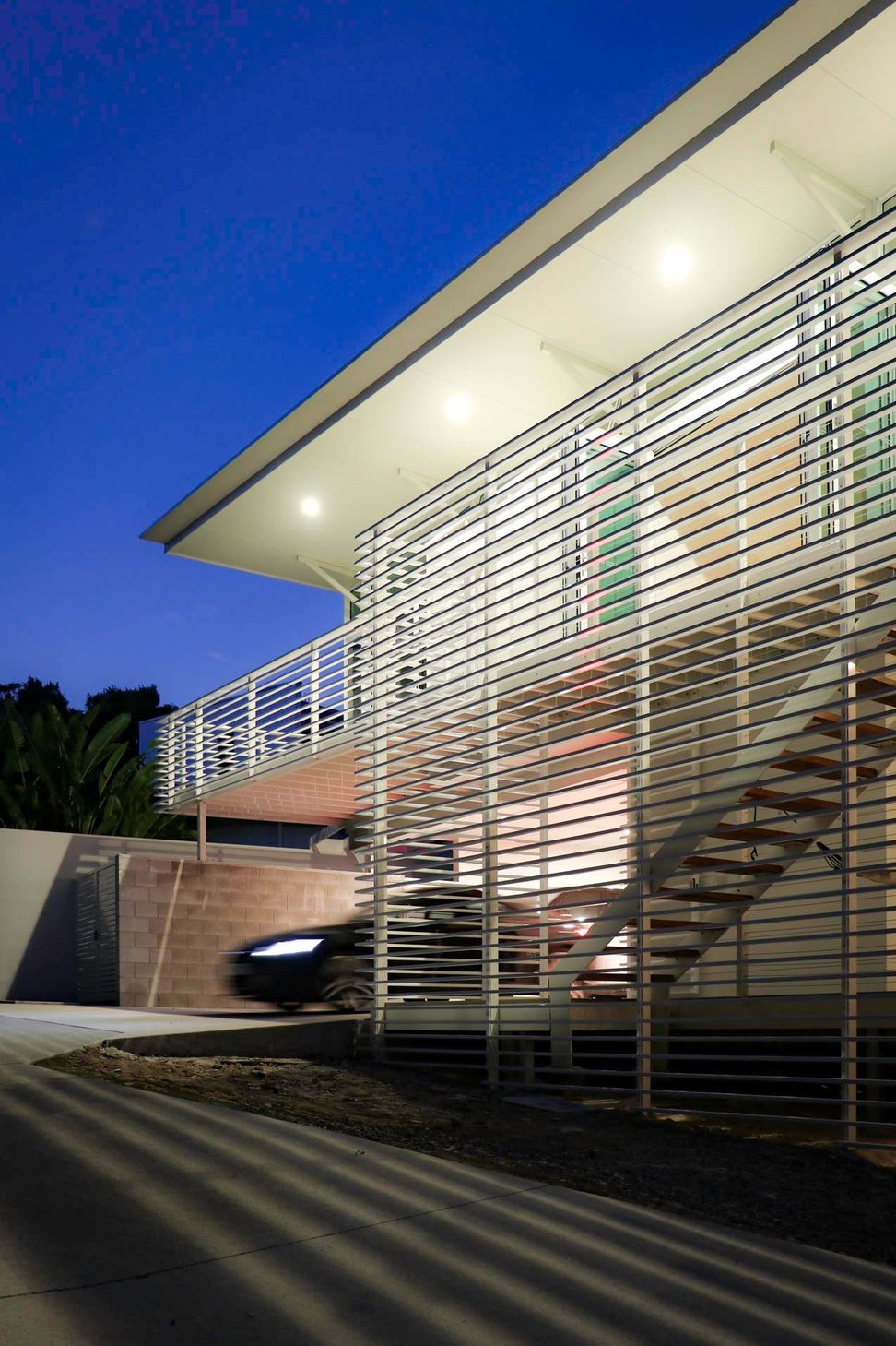 105 Residence - Exterior. Cantilevered deck and screens against a deep blue sky.