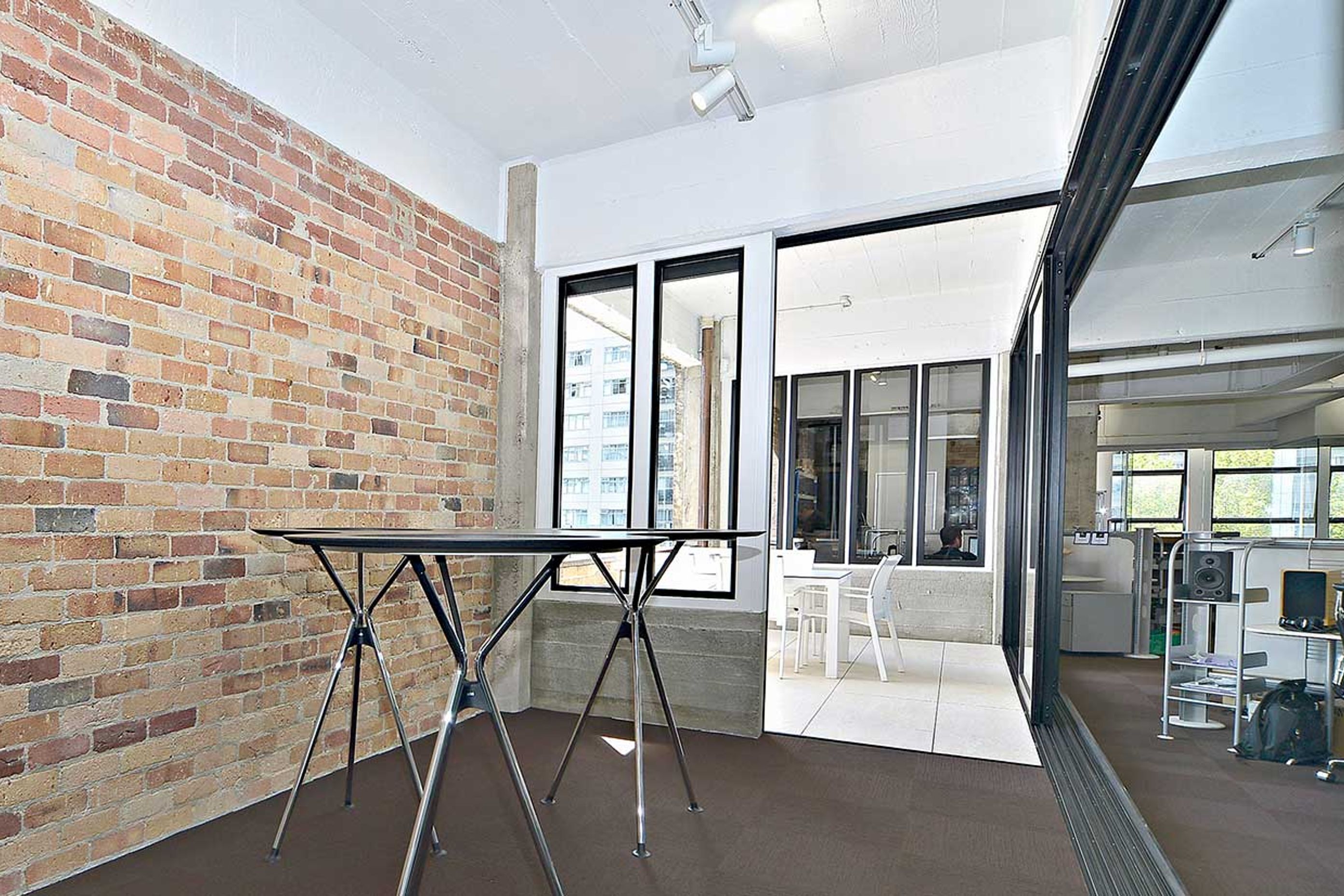 A large part of one of the external brick walls was taken down to create a sunny external deck area with brick balustrade and a bank of large sliding doors.