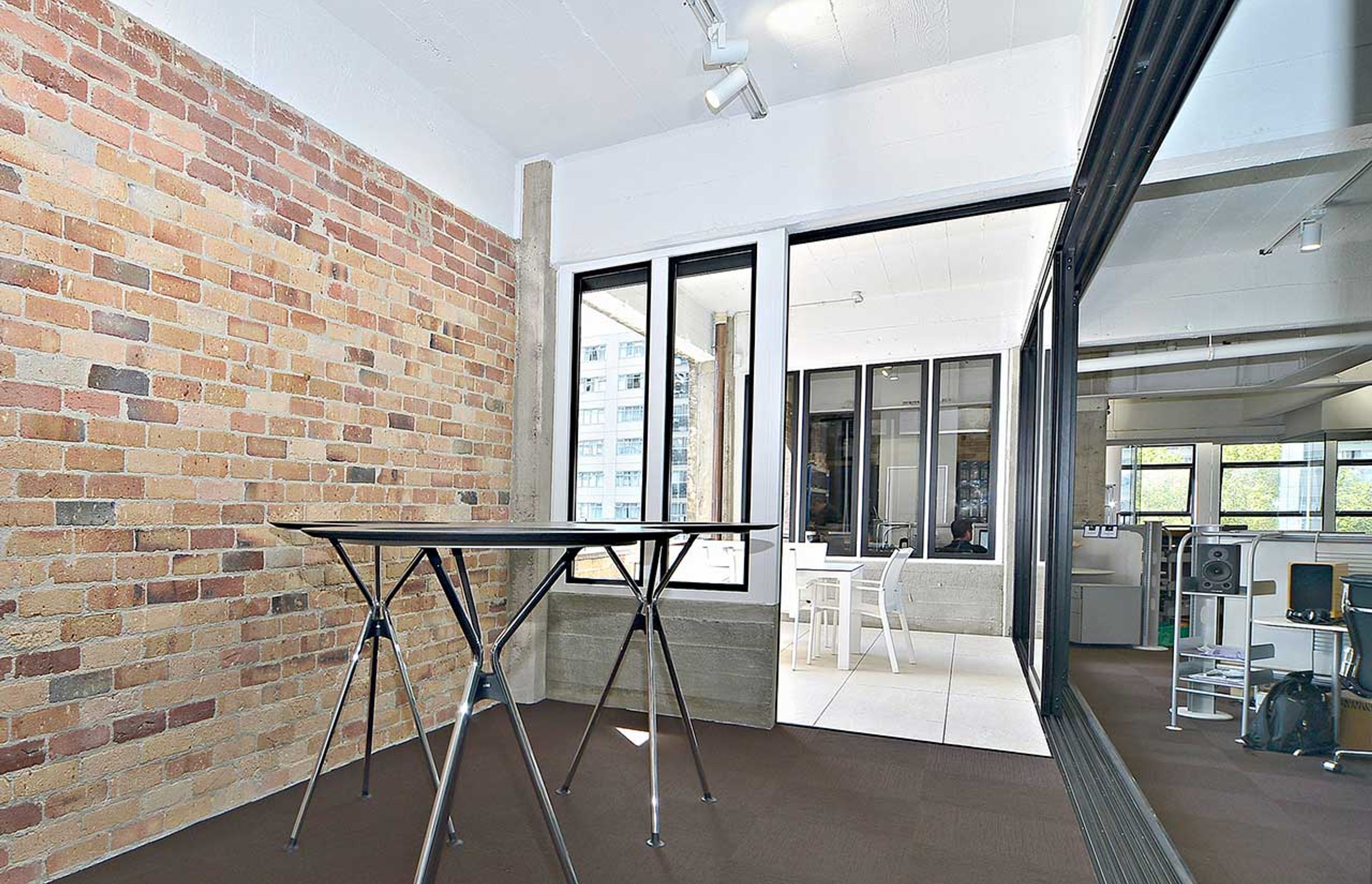 A large part of one of the external brick walls was taken down to create a sunny external deck area with brick balustrade and a bank of large sliding doors.