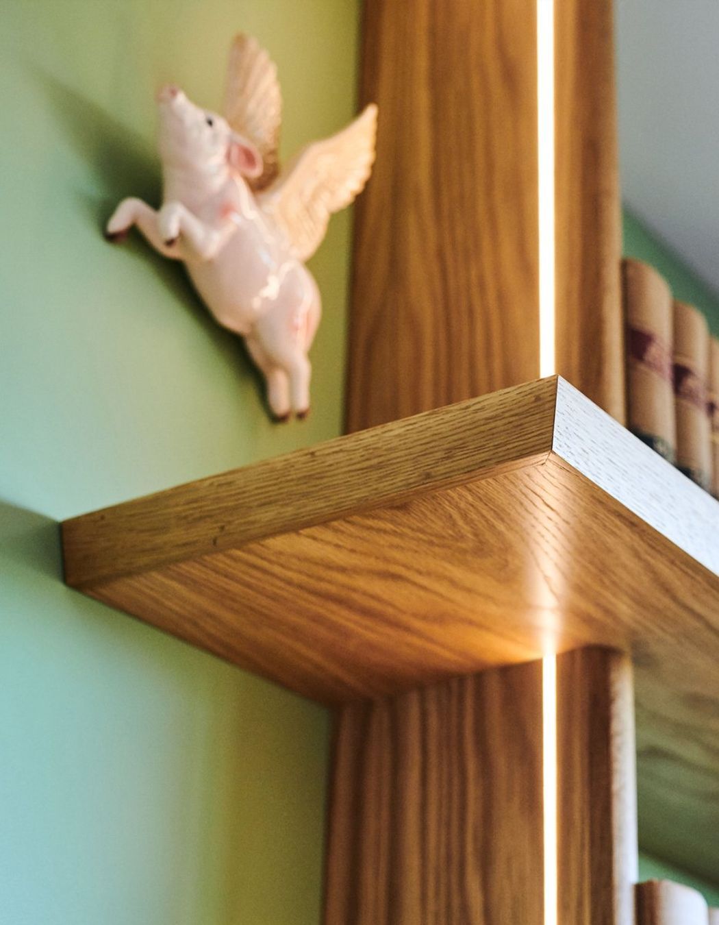 Side emitting LED strip lighting illuminates the artwork between the shelves at night.