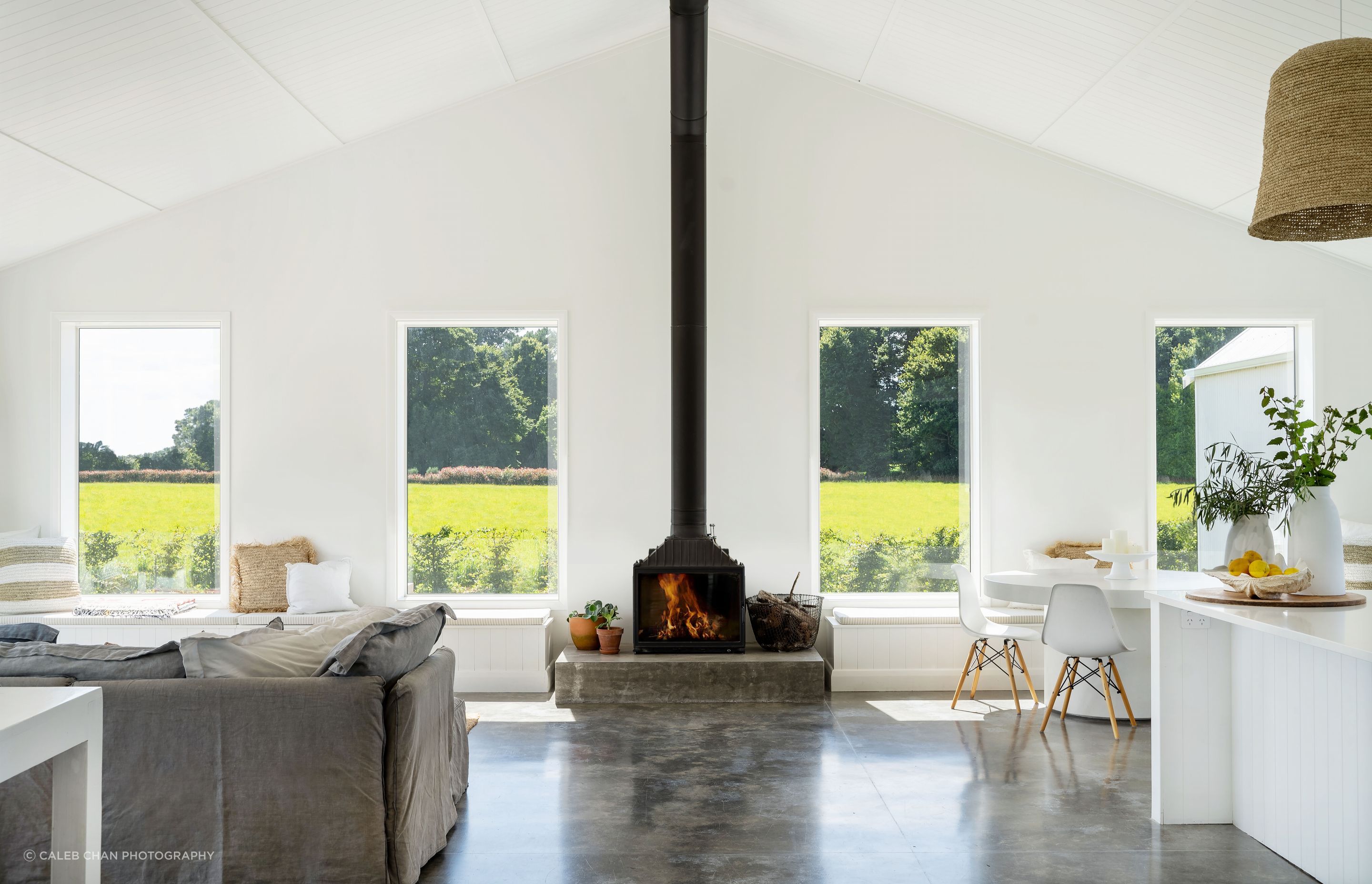 The French Cheminees Philippe cast-iron fireplace contrasts against the white interior to create a focal point in the home