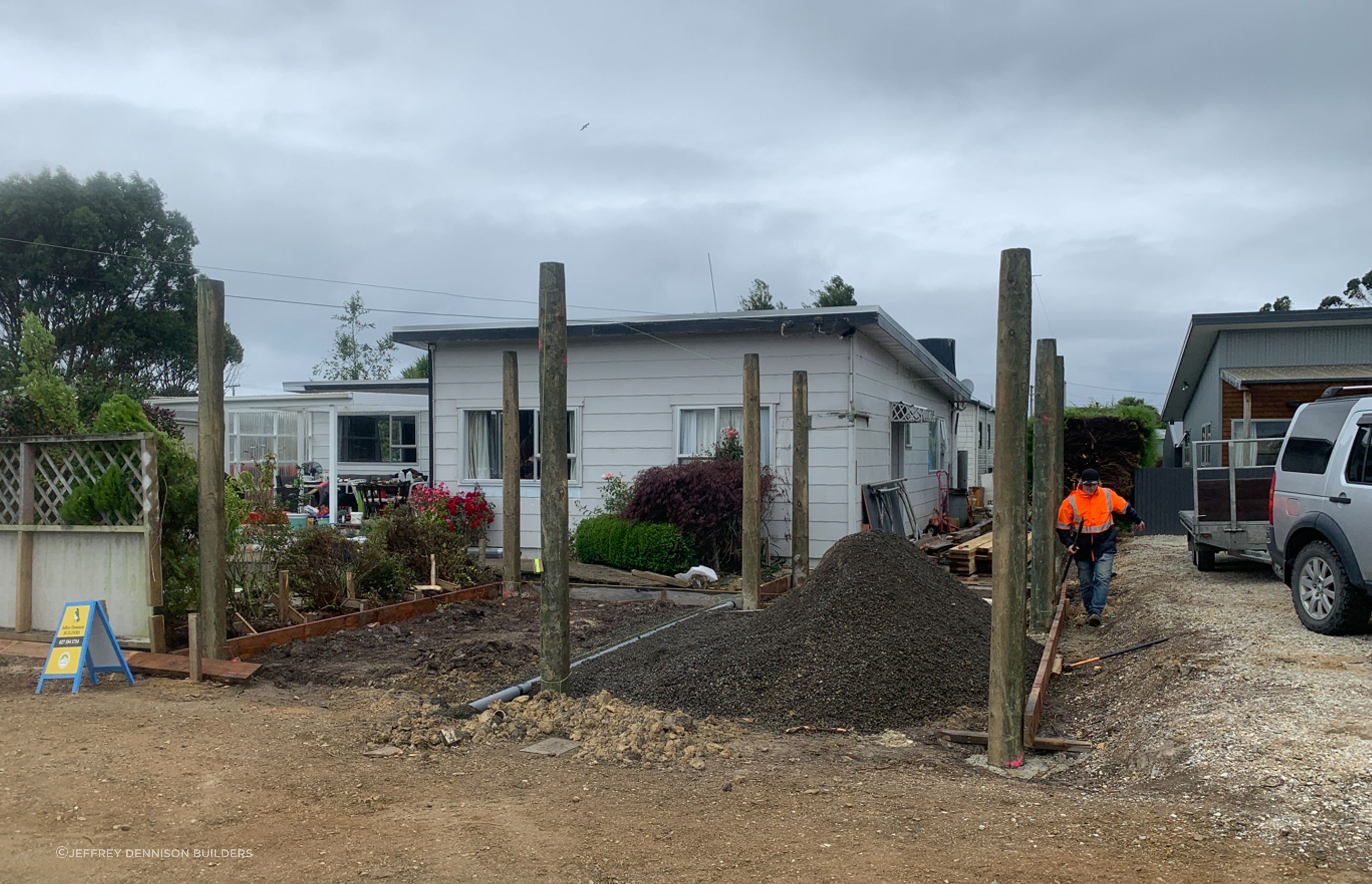 Concrete placed in post holes, base gravel ready to be spread out.