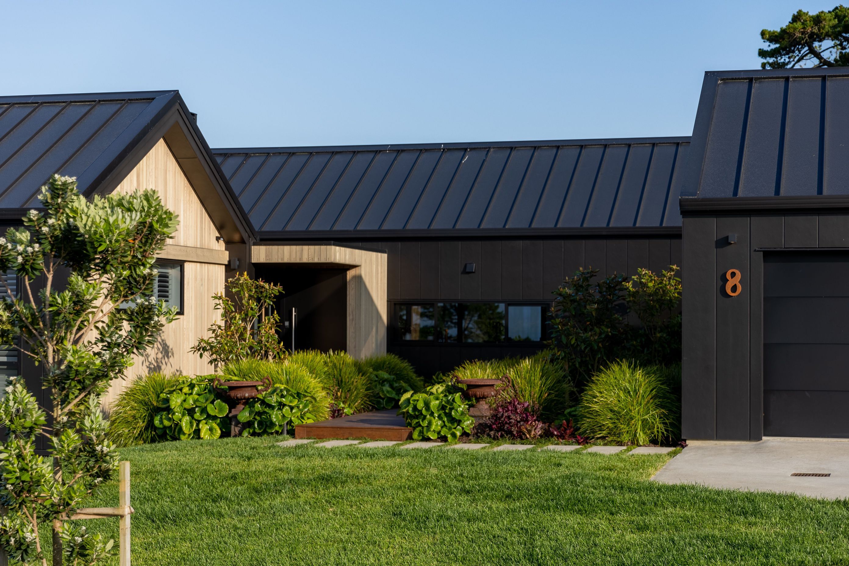 Black painted stria contrasts with softer warmth of with cedar feature walls this striking home.