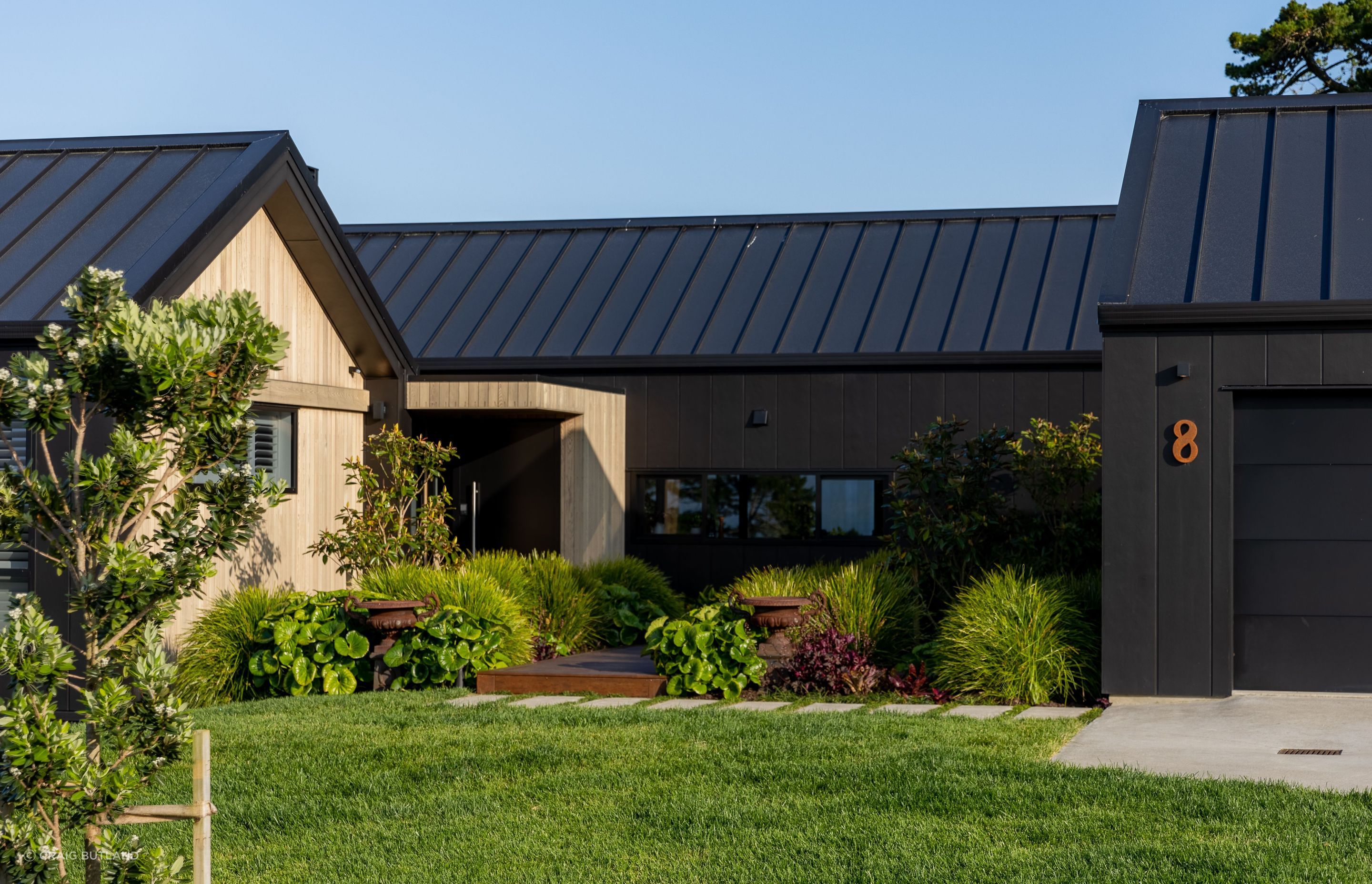 Black painted stria contrasts with softer warmth of with cedar feature walls this striking home.