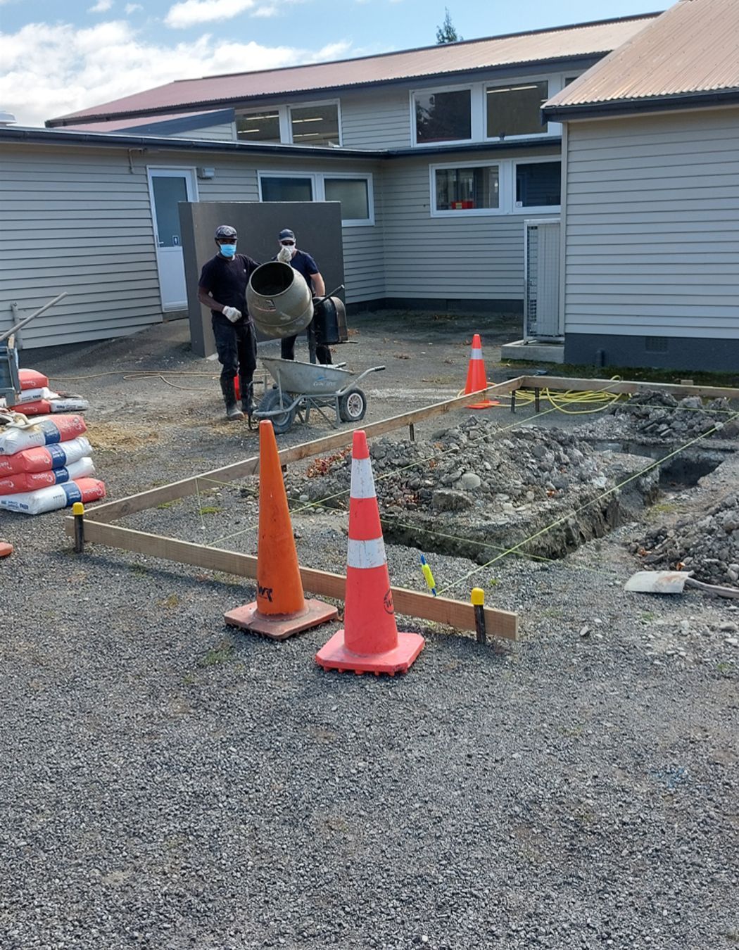 Two of our team mixing up concrete for the foundation whilst another floats the concrete on the other side
