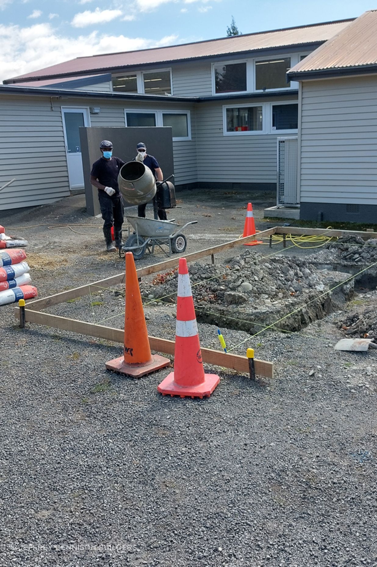 Two of our team mixing up concrete for the foundation whilst another floats the concrete on the other side
