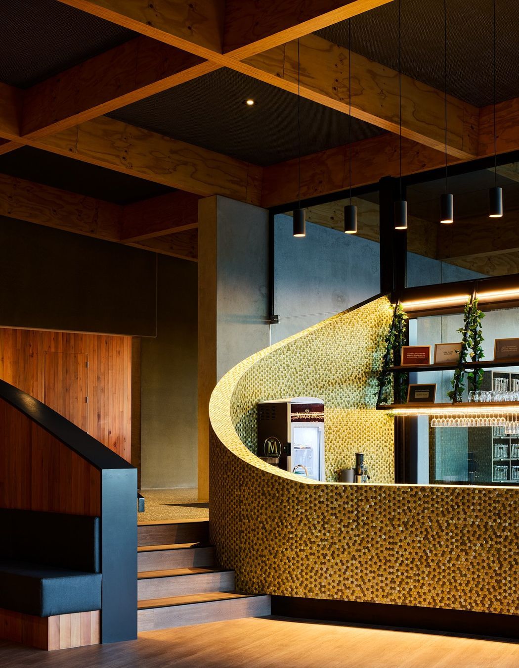 The cafe and bar features a sweeping, curved wall and reclaimed timber cladding.
