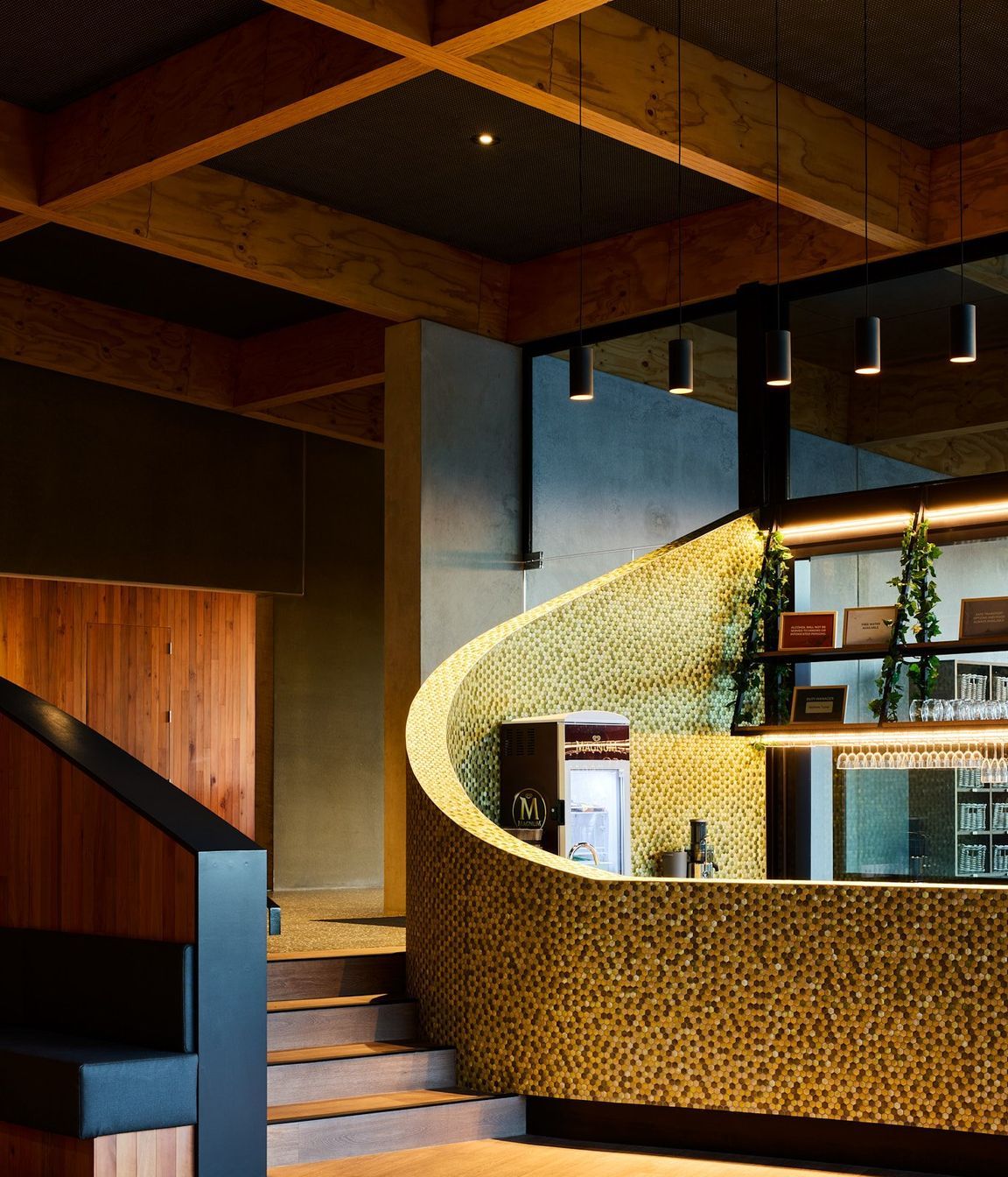 The cafe and bar features a sweeping, curved wall and reclaimed timber cladding.