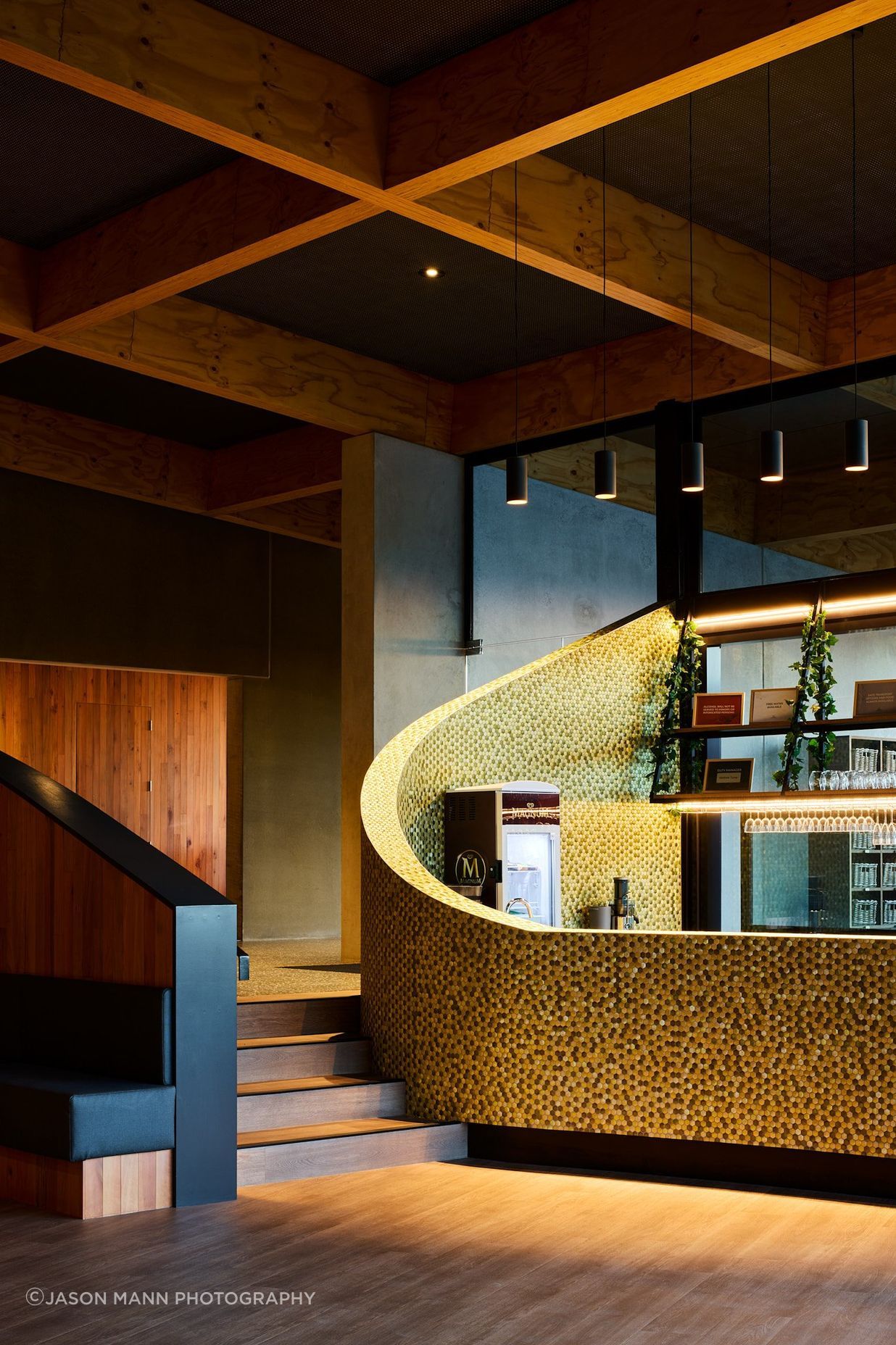 The cafe and bar features a sweeping, curved wall and reclaimed timber cladding.