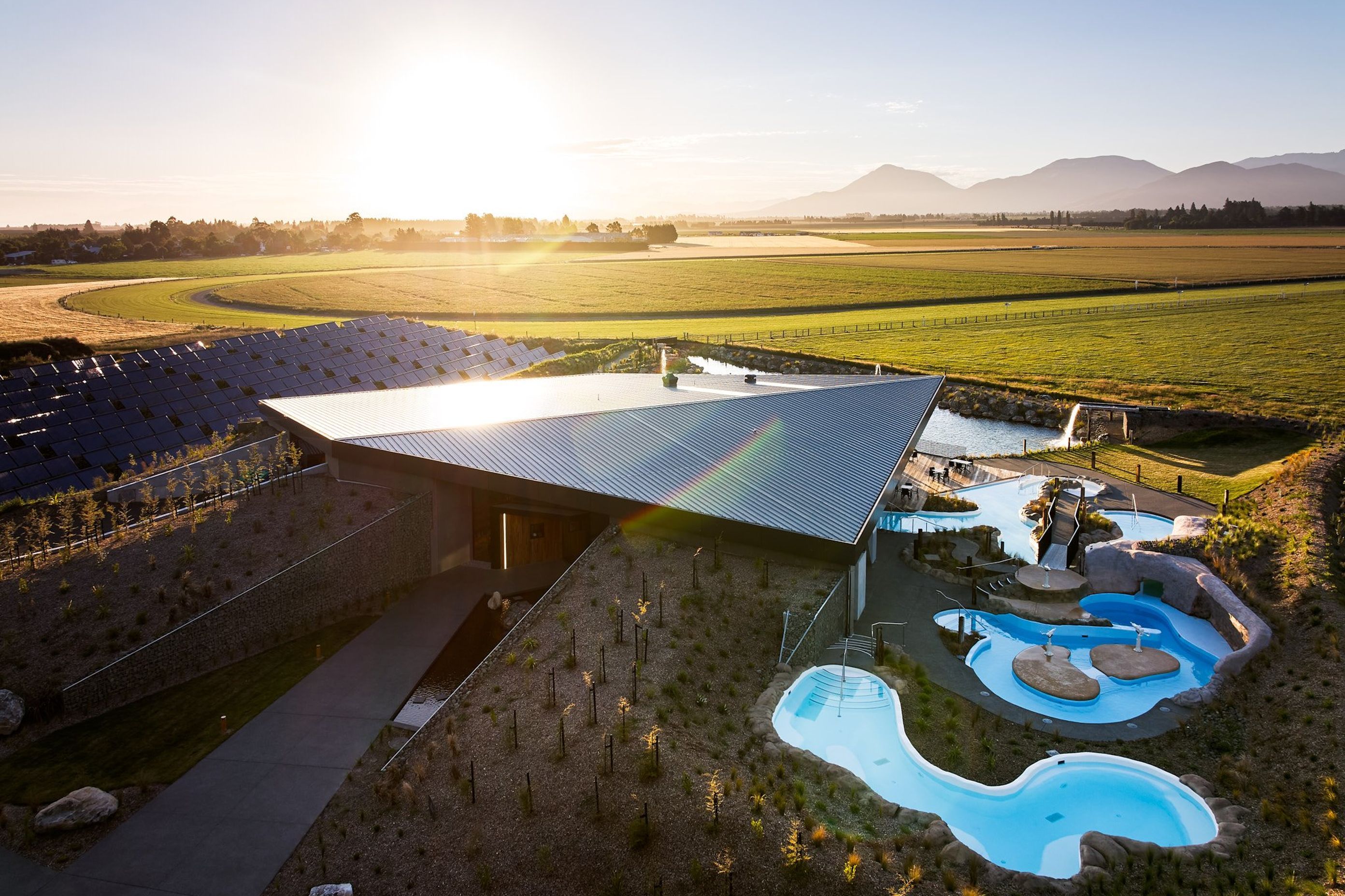 To the left of the building you can spot the solar thermal panels, and at the very back, the pond that takes in the excess heat during summer.