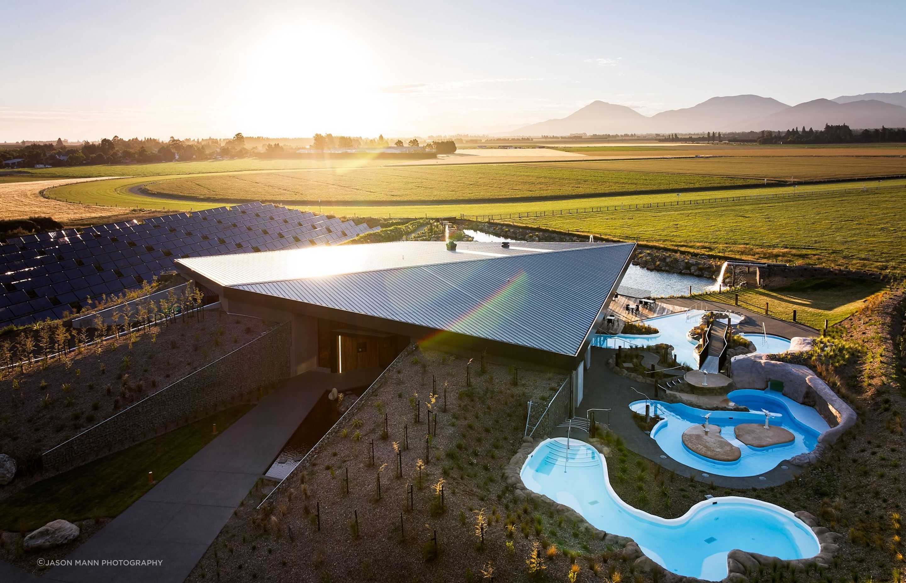 To the left of the building you can spot the solar thermal panels, and at the very back, the pond that takes in the excess heat during summer.