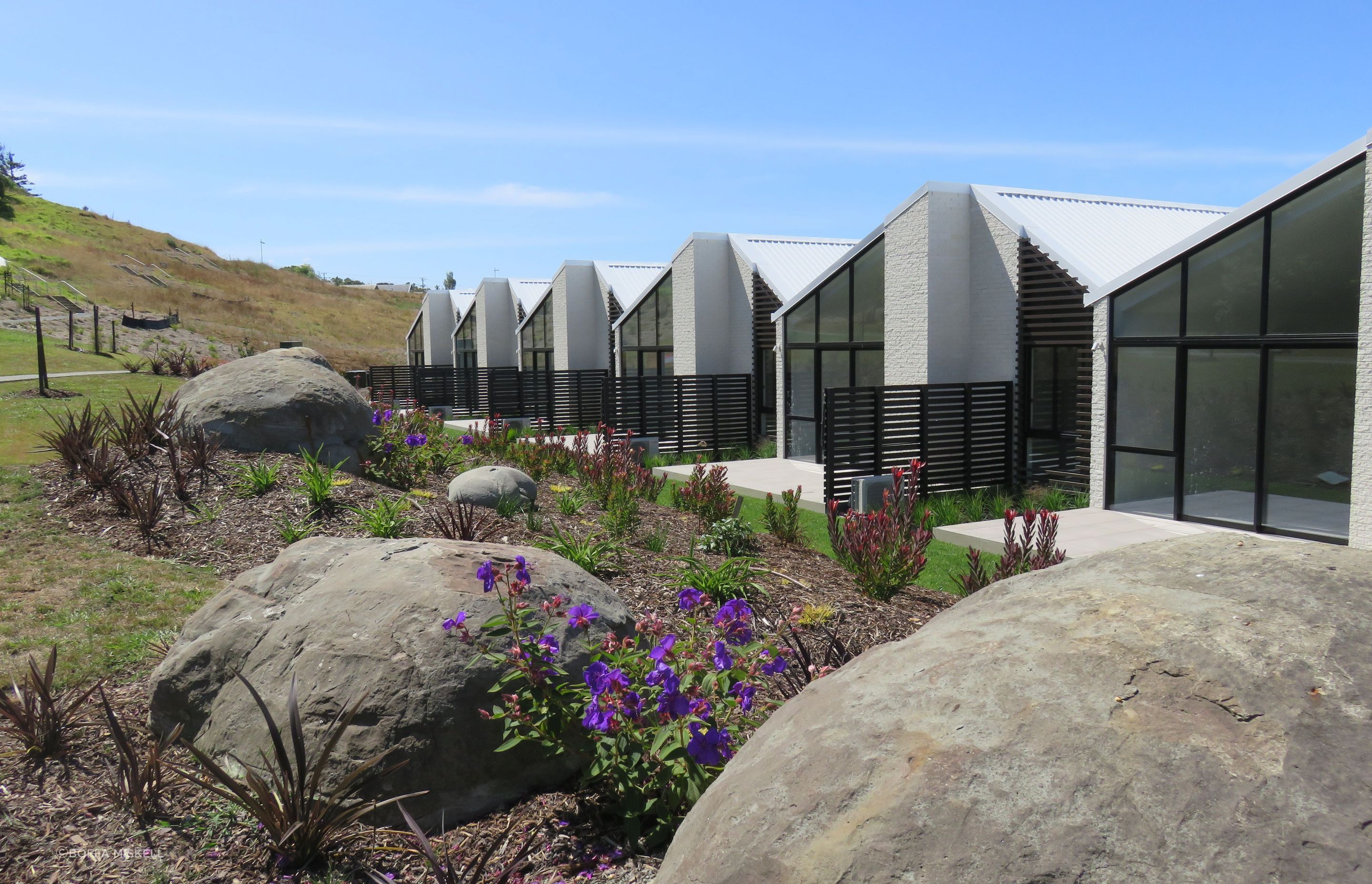 Large boulders have been incorporated throughout the landscaping as natural play elements for children.