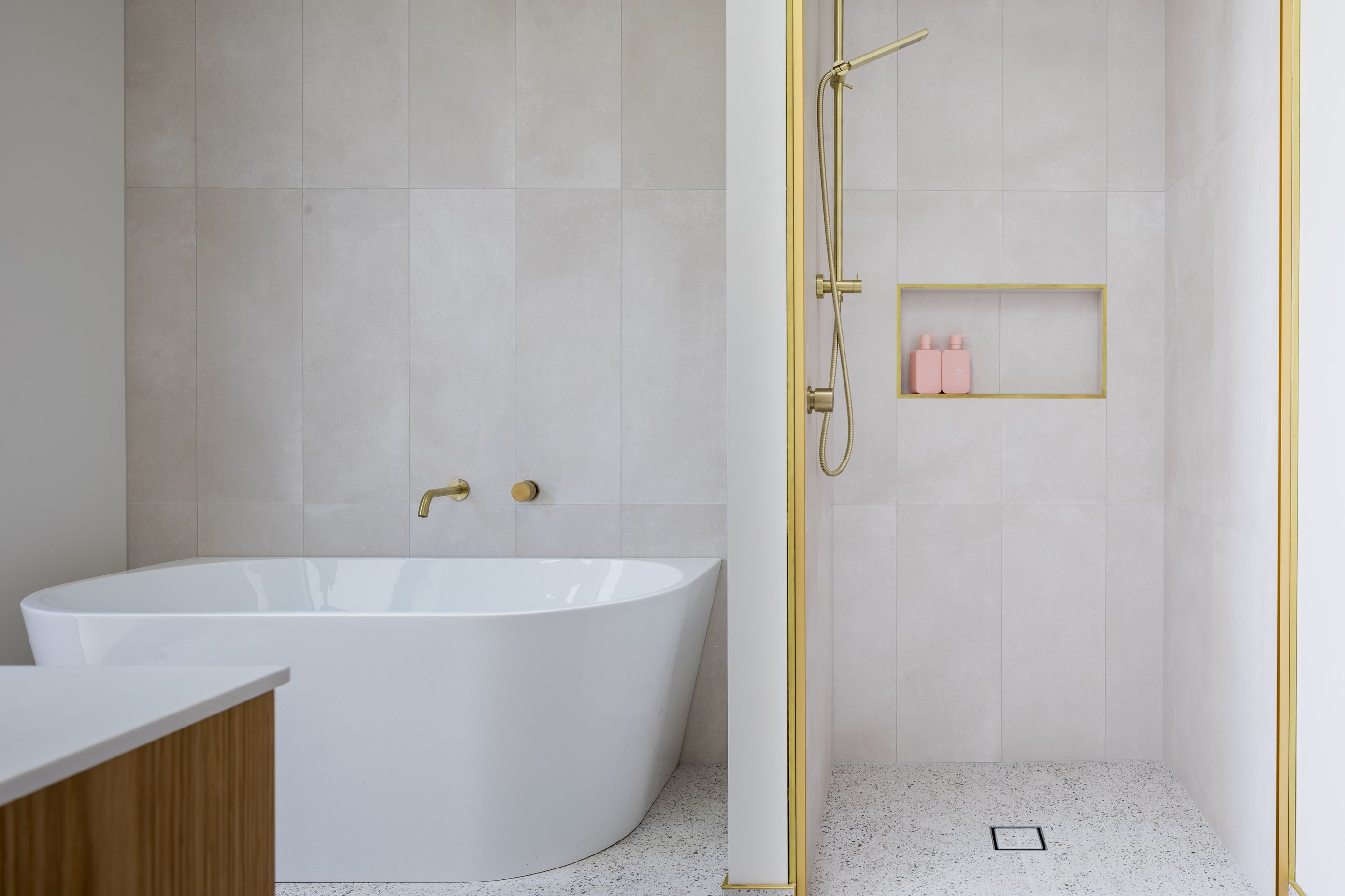 Natural tones and brass highlights create a luxurious aesthetic in the main bathroom.