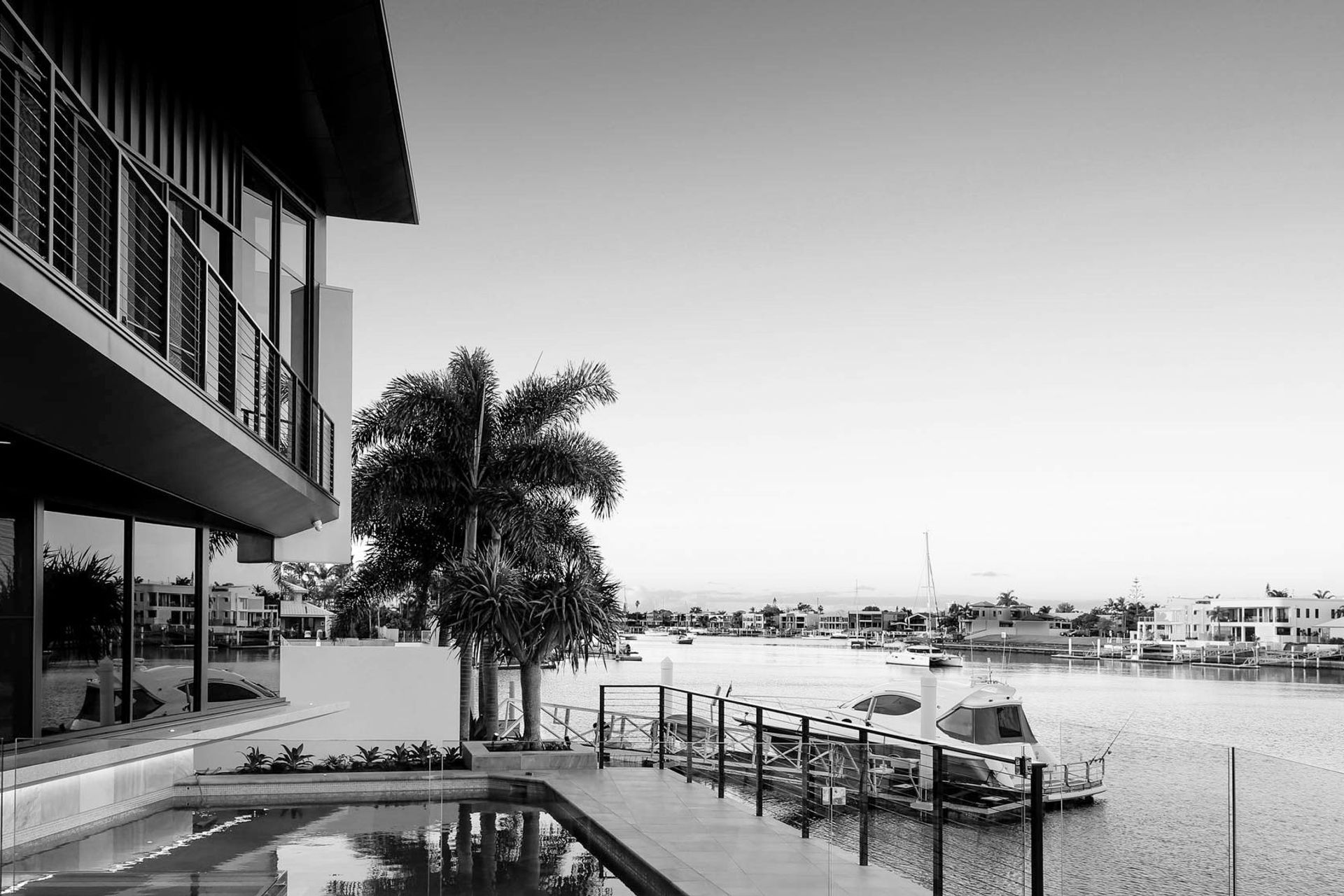 Robbie Residence - Exterior. Canal frontage and jetty in black and white.