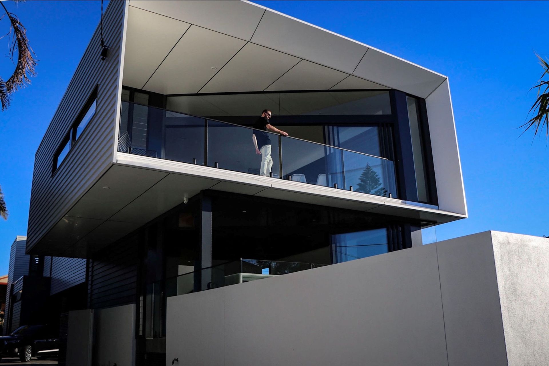 Kruger Residence - Exterior. Cantilevered balcony and glazing against a blue sky.