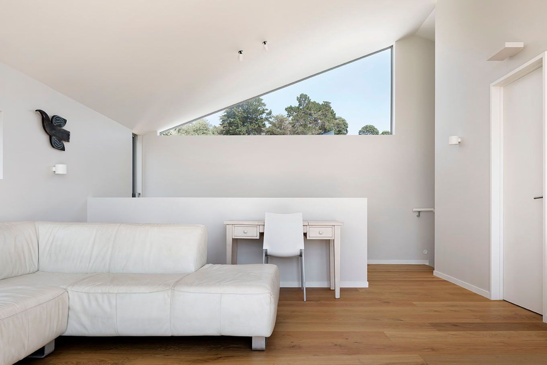 Apertures across the space look out to trees/ treetops