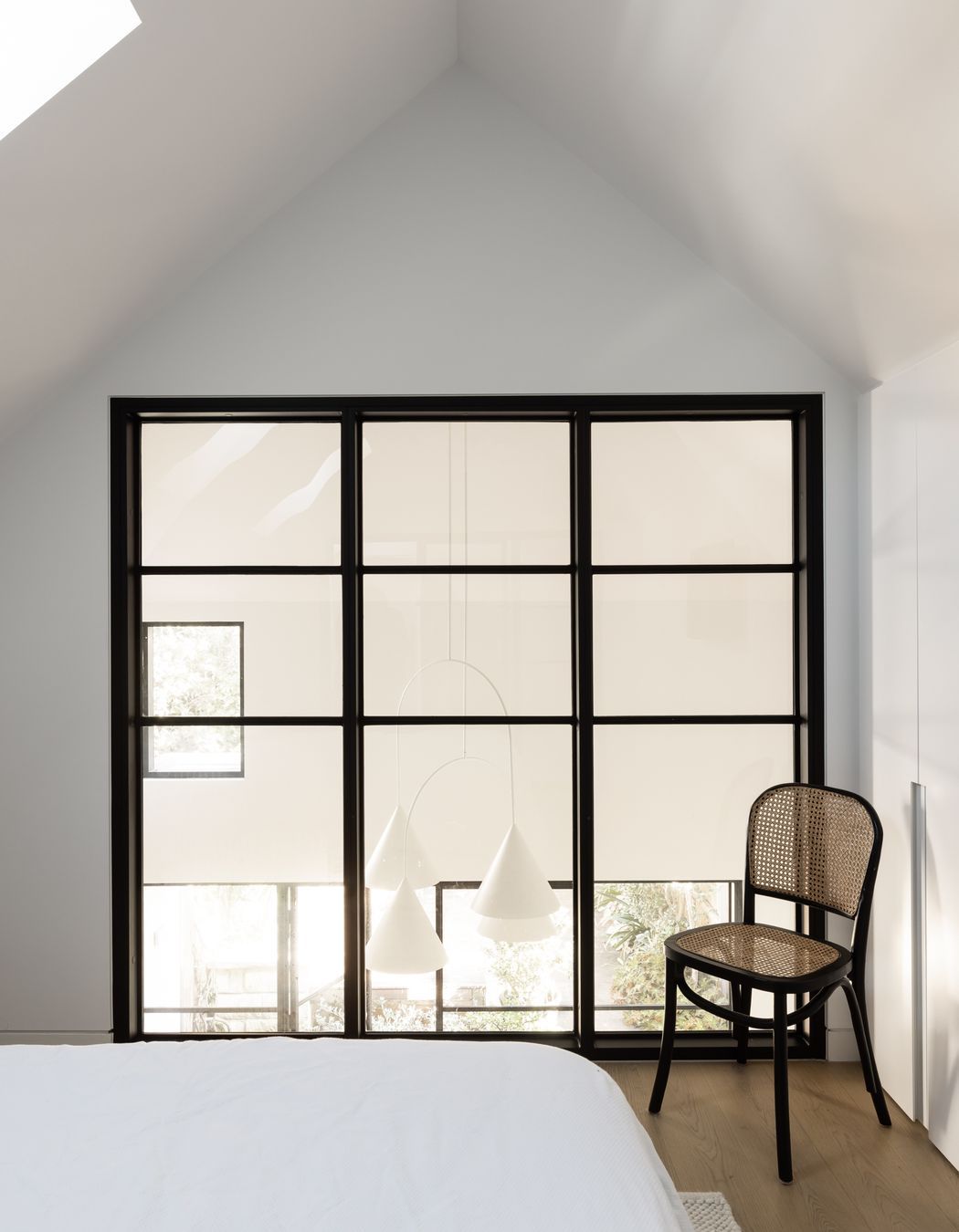 Sophisticated bedroom addition filled with natural light from the inserted skylights