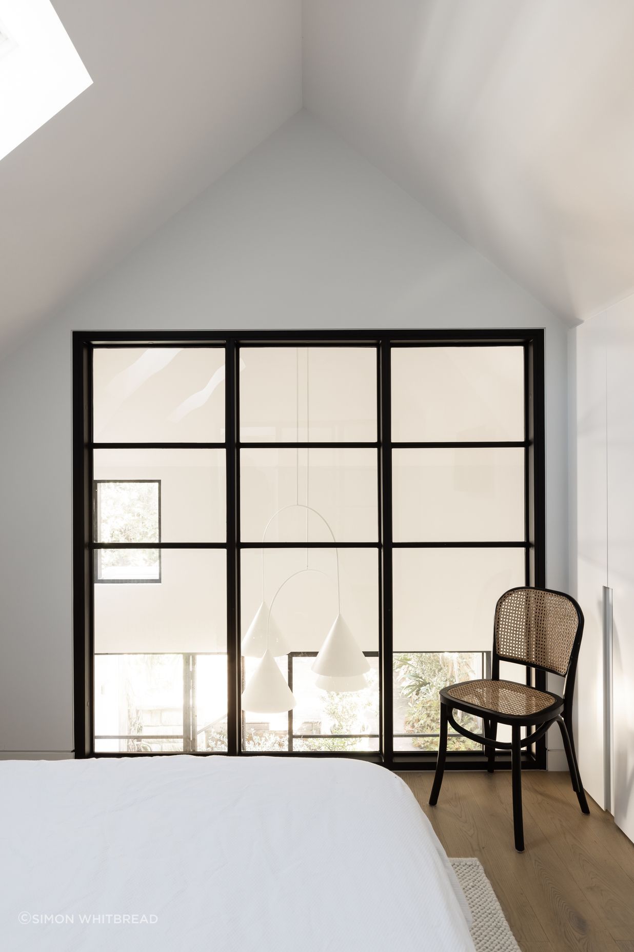Sophisticated bedroom addition filled with natural light from the inserted skylights