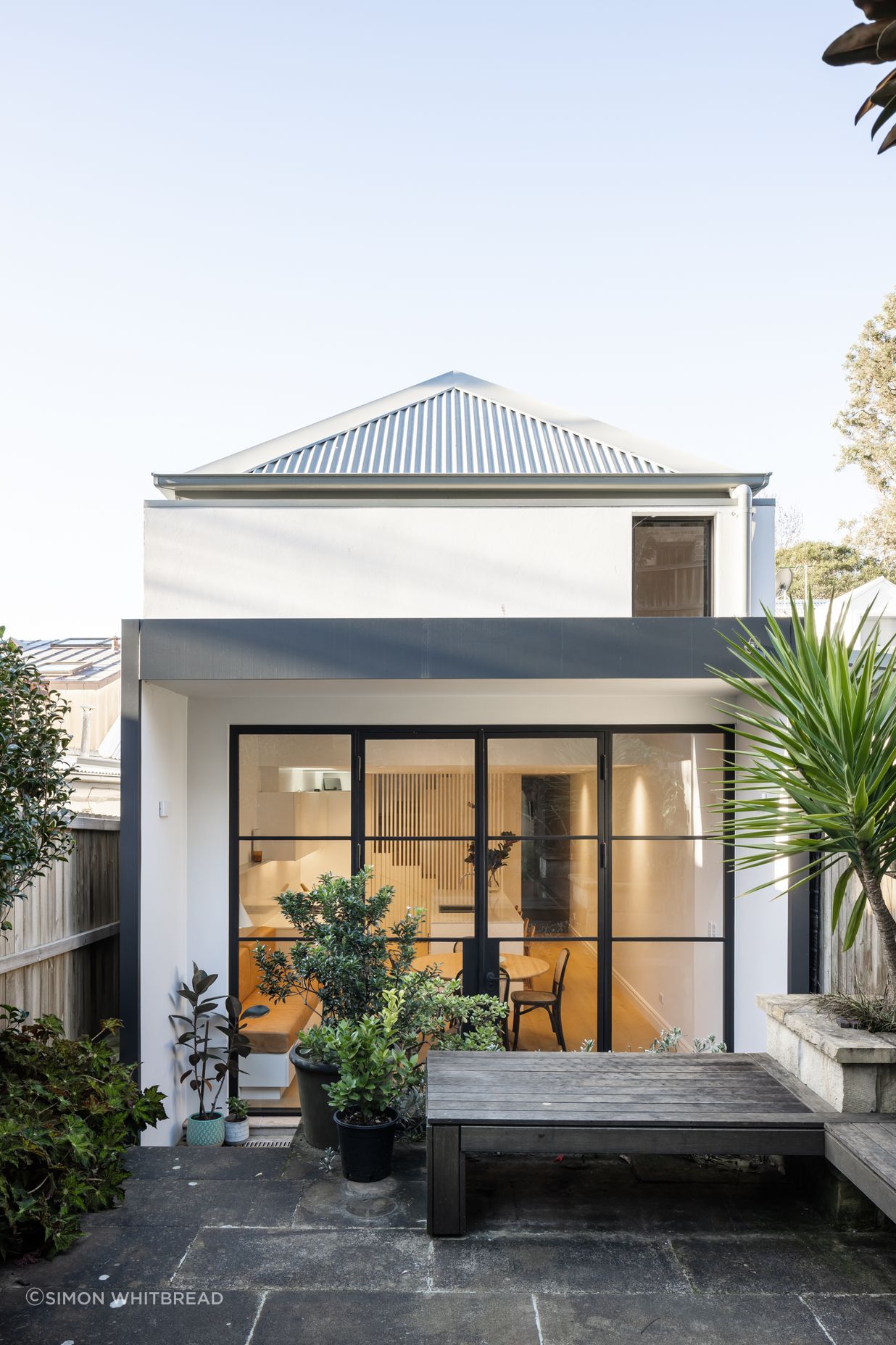 Sensitive rear extension with steel doors framing the interior and exterior spaces