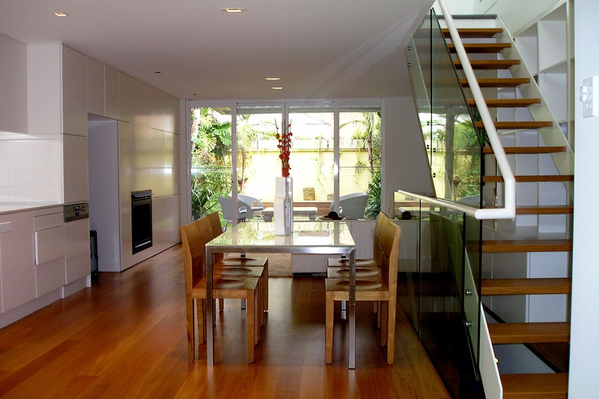 Kitchen, dining and living beyond- timber, steel and glass feature stair at side